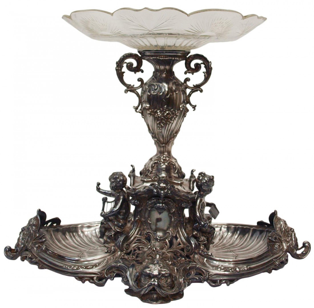 MONUMENTAL WMF SILVER PLATE FIGURAL CENTERPIECE: Impressive WMF (Württemberger Metallwarenfabrik) silver plate centerpiece, a shallow, cut glass dish surmounting the monumental silver plate base profusely decorated in the rocaille taste with scroll