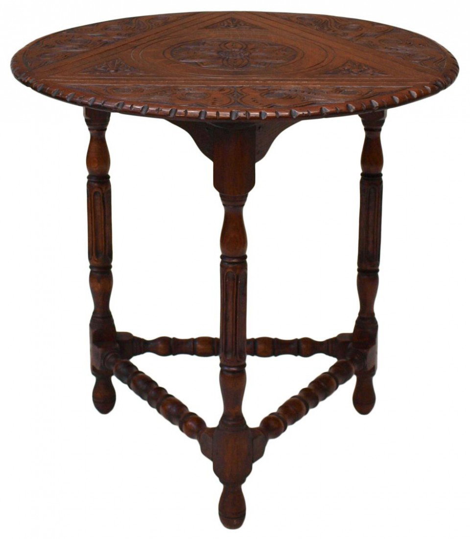 EDWARDIAN CARVED OAK ENVELOPE TABLE, C. 1905: Edwardian foliate carved oak triangular envelope table, c. 1905, a swivel top with three drop leaves rising to form a circular top, three reeded and fluted legs joined by turned stretchers, 25" h, 26"
