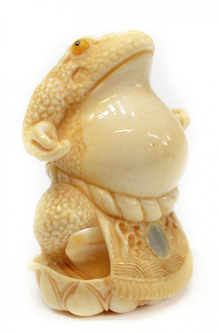 JAPANESE CARVED IVORY STANDING FROG NETSUKE: **This lot will not be shipped Internationally** Japanese ivory netsuke carved in the form of a frog standing on a melon, appearing to have human-like hands, apron tied at back inset with a mother-of-