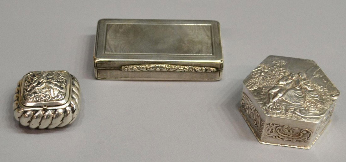 STERLING SILVER & PLATE REPOUSSE DRESSER BOXES: (lot of 3) Sterling silver and plate dresser boxes: (1) sterling box of hexagonal form, repousse depictions of a courting couple, the interior in a gilded wash, 2"w; (1) small silver or plate box havi