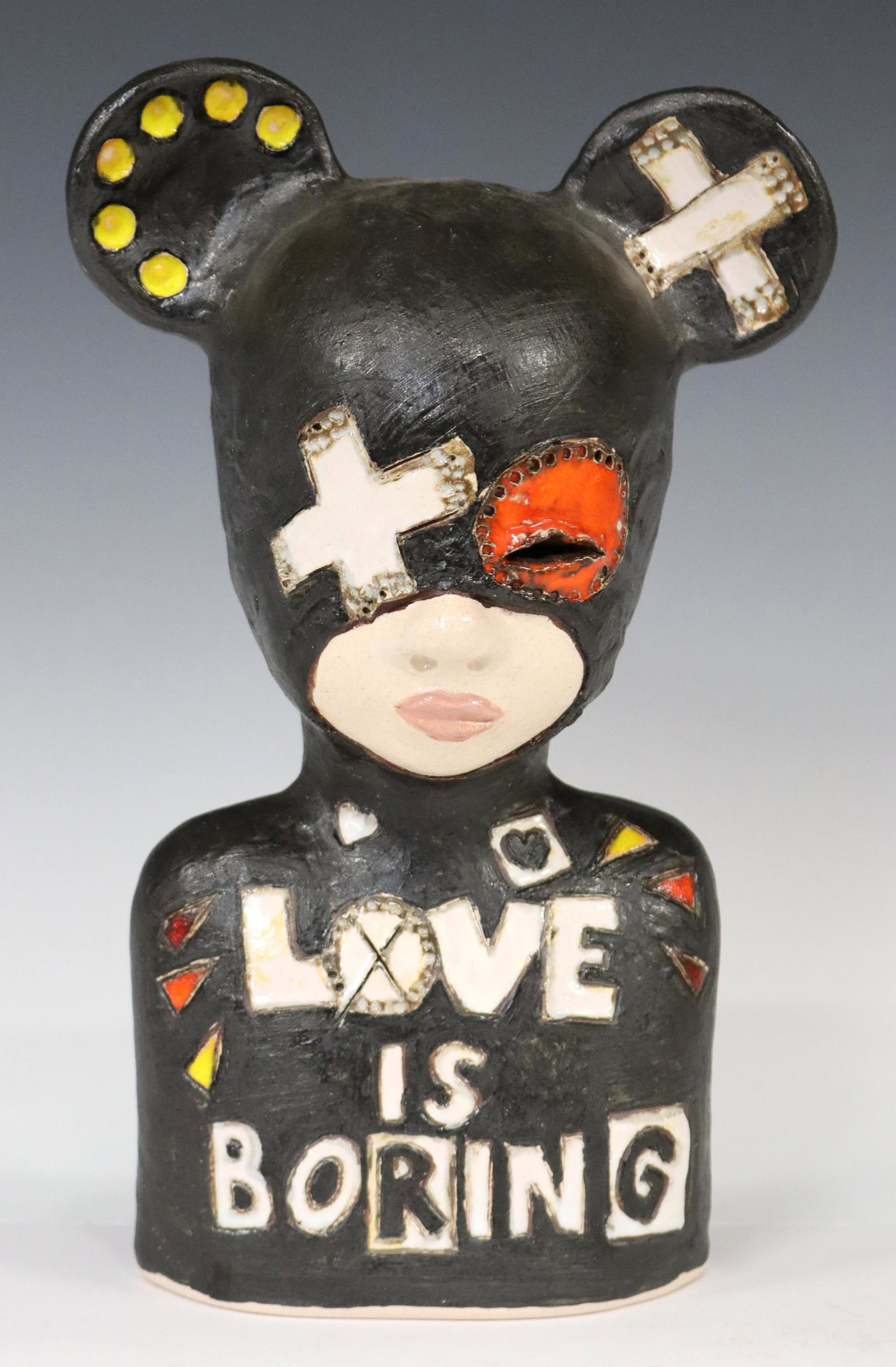 IWO RYNKIEWICZ (B.1970) CERAMIC 'KID' SCULPTURE: Pop art style polychrome ceramic "Love is Boring" kid sculpture, Iwo Rynkiewicz (Polish, b.1970), signed to back, approx 10 3/8"h, 5.25"w, 5.25"d, 3lbs **Provenance: Designer Courtney Blanton's CBI St
