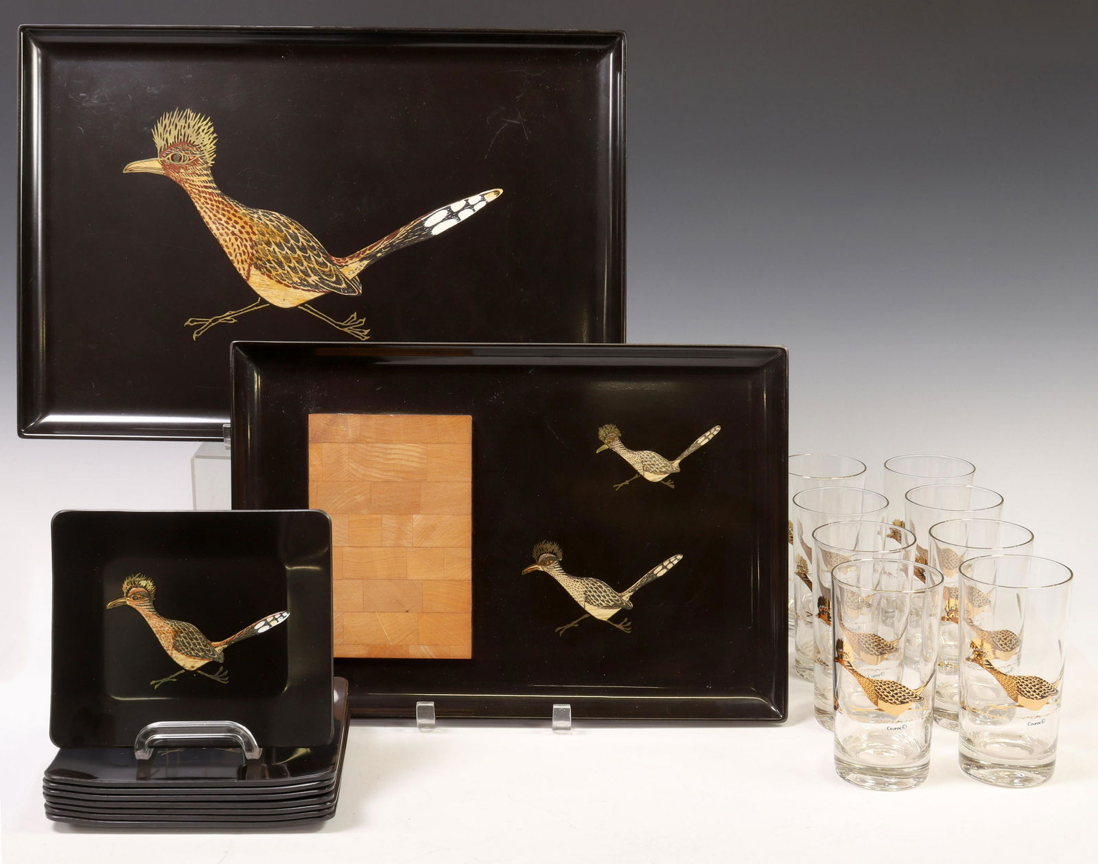 (18) COUROC ROADRUNNER GLASSES, PLATES & TRAYS: (lot of 18) Couroc of Monterey, roadrunner pattern, including: (8) highball glasses, approx 5.5"h, 2.75"diam, (8) individual plates, approx 7"l, 8"w, (1) cheese board tray, approx 15 3/8"l, 10.75"w, (