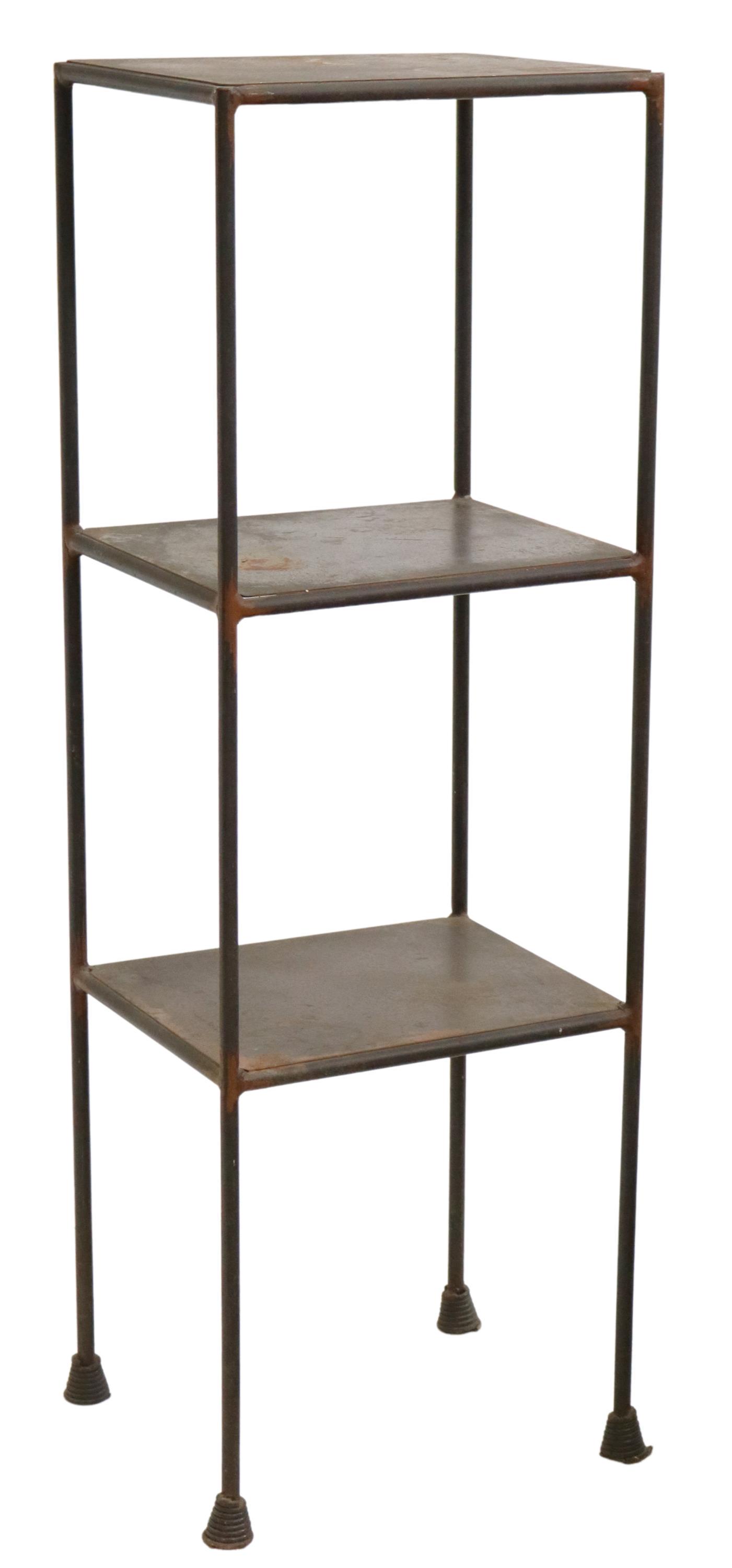 INDUSTRIAL IRON THREE-SHELF STANDING ETAGERE: Industrial iron standing etagere, 20th c., three shelves, rising on cylindrical legs, ending on coiled feet, approx 59 1/8"h, 21"w, 17.25"d Start Price: $100.00