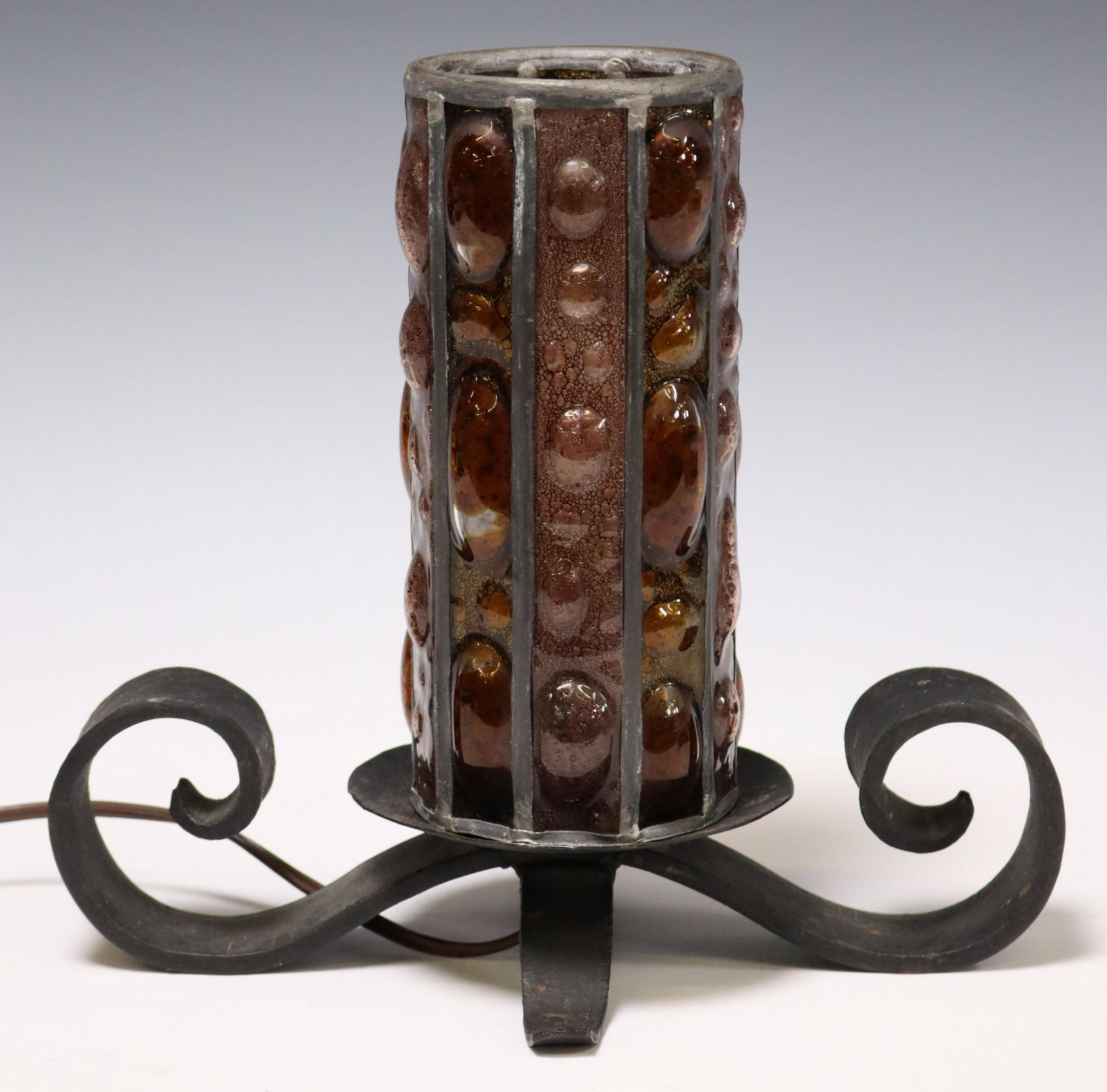 FELIPE DELFINGER (ATTRIB) IRON & GLASS TABLE LAMP: Wrought iron and textured glass single-light table lamp, attributed by consignor to Felipe Delfinger (Mexico, 20th c.), mid 20th c., having cylindrical shade with iron frame and bubbled glass panels, 