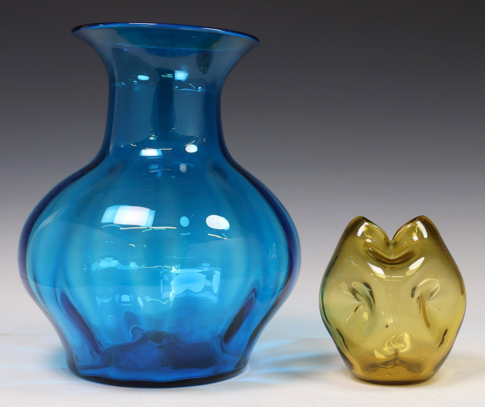 (2) BLENKO (ATTRIB) COLORED BLOWN ART GLASS VASES: (lot of 2) Colored blown art glass vases, attributed to Blenko, 20th c., including: (1) having flared rim, over tapered body, approx 14"h, 10"diam; (1) with dual sloped openings to top, pinched square