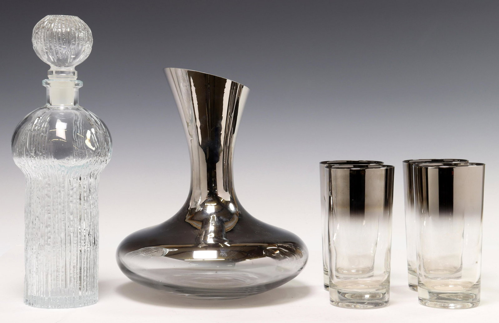 (6) MODERN GLASS BARWARE, DOROTHY THORPE STYLE: (lot of 6) Modern glassware, including: (1) molded glass decanter and stopper, approx 11.5"h, 4"diam, (4) glass tumblers with silver fade rims, in the manner of Dorothy Thorpe (American, 1901-1989), a