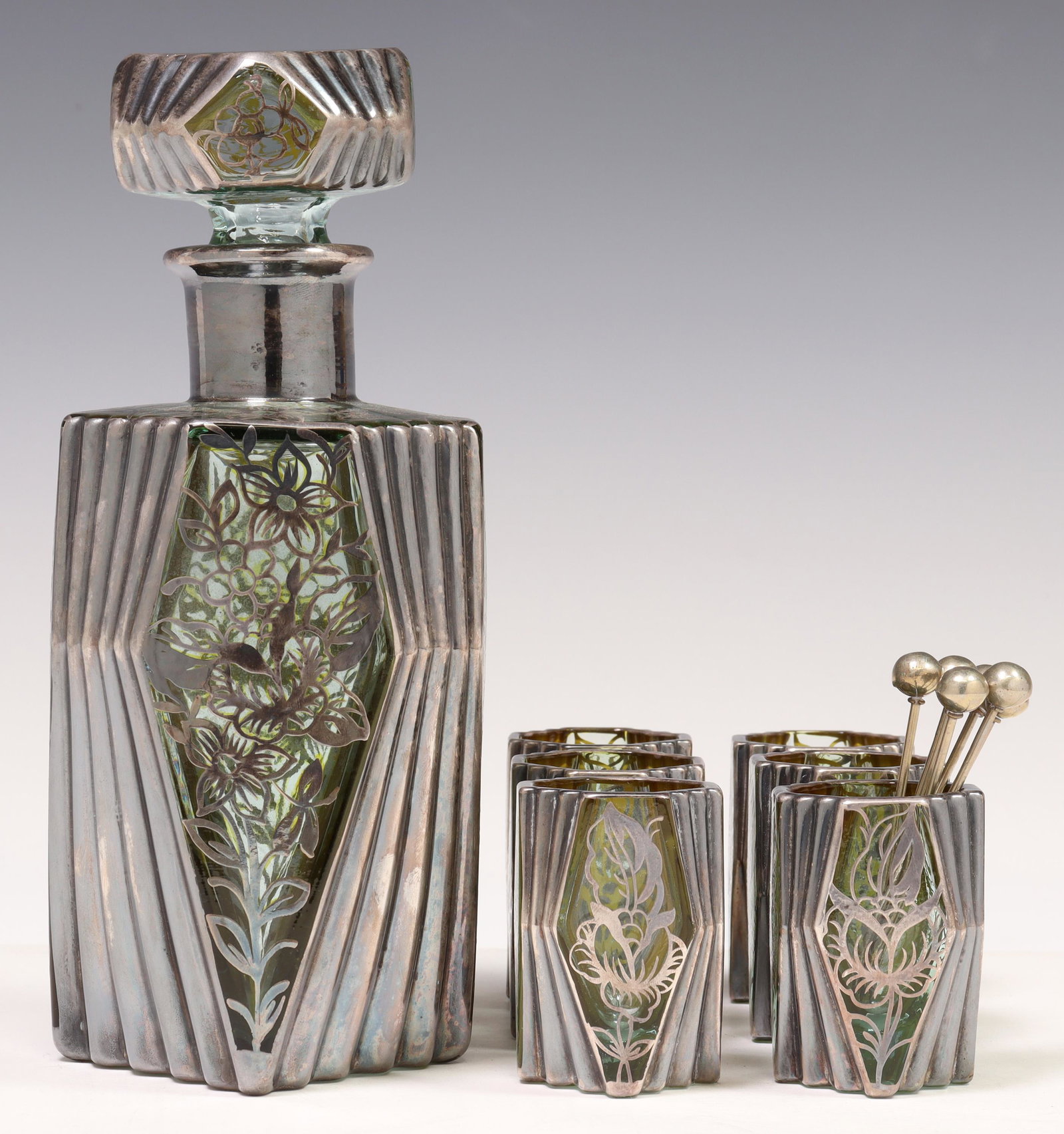 (7) CZECH ART DECO SILVER OVERLAY LIQUEUR SERVICE: (lot of 7) Czechoslovakian Art Deco silver overlay liqueur service, c.1930s, green glass frame with silver overlay flowers, geometric fanned side panels, unmarked, including: (1) decanter with stopper