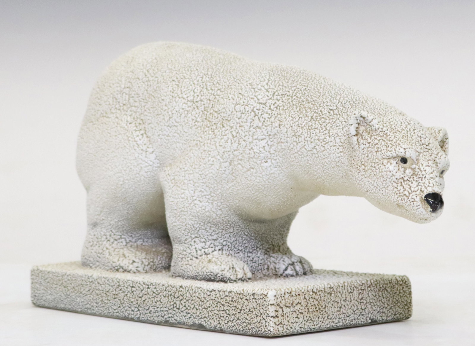 GLAZED CERAMIC SCULPTURE OF A POLAR BEAR: Ceramic sculpture of a polar bear, in a textured glaze, approx 8.75"h, 15.5"w, 6"d, 7lbs Start Price: $80.00