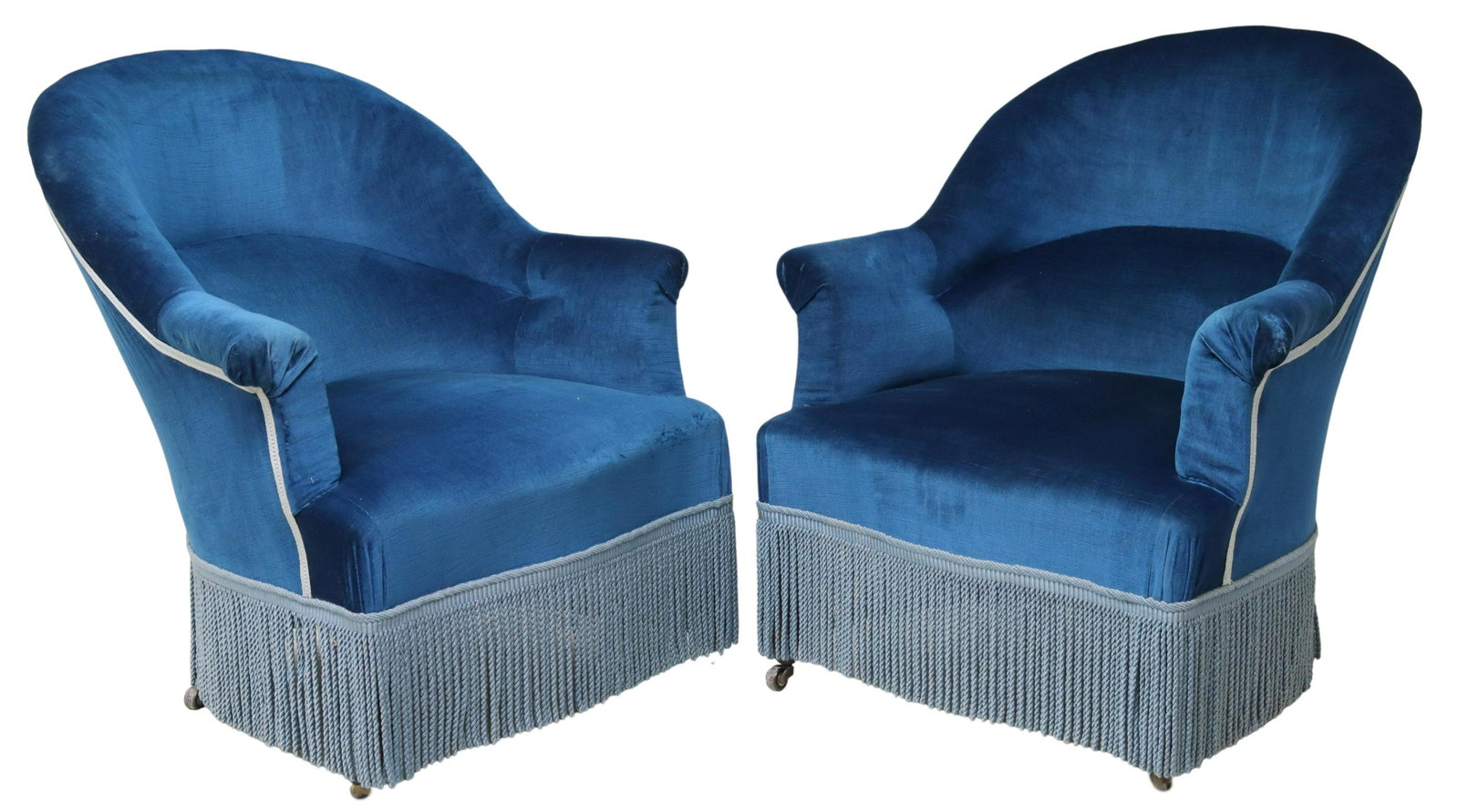 (2) NAPOLEON III PERIOD UPHOLSTERED BERGERES: (pair) Napoleon III period armchairs, late 19th c., having rounded back, in a blue upholstery, over rope fringe, rising on cabriole legs, ending on casters, approx 33.25"h, 31.25"w, 30"d, seat height: