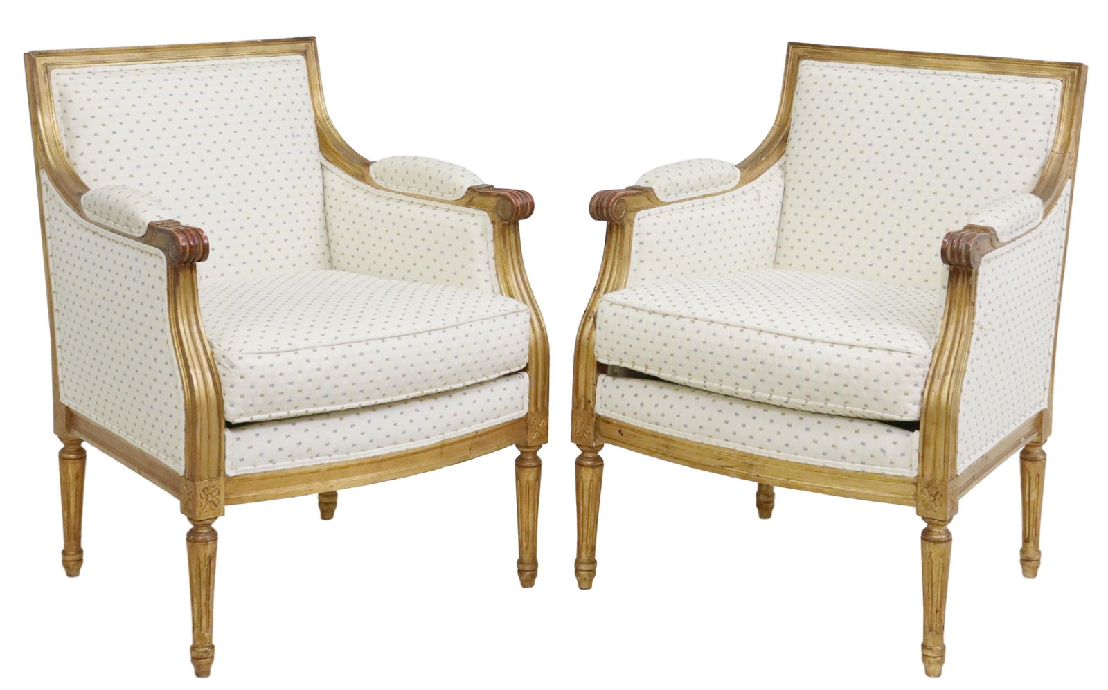 (2) LOUIS XVI STYLE UPHOLSTERED GILTWOOD BERGERES: (pair) French Louis XVI style giltwood armchairs/ bergeres, late 19th c., in later patterned fabric upholstery, having molded frame, scrolled handholds, removable seat cushion, rising on fluted tapere