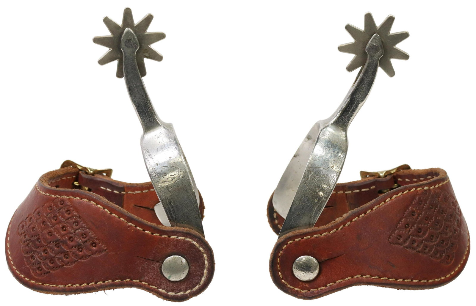 WESTERN STAINLESS LONGHORN COWBOY SPURS: (pair) Western stainless spurs, outside heelband with engraved longhorn, 1.75" rowels, nine points, tooled leather straps with contrasting stitching, yoke: approx 3"w, 3.5"d; 1.25lbs total Start Price