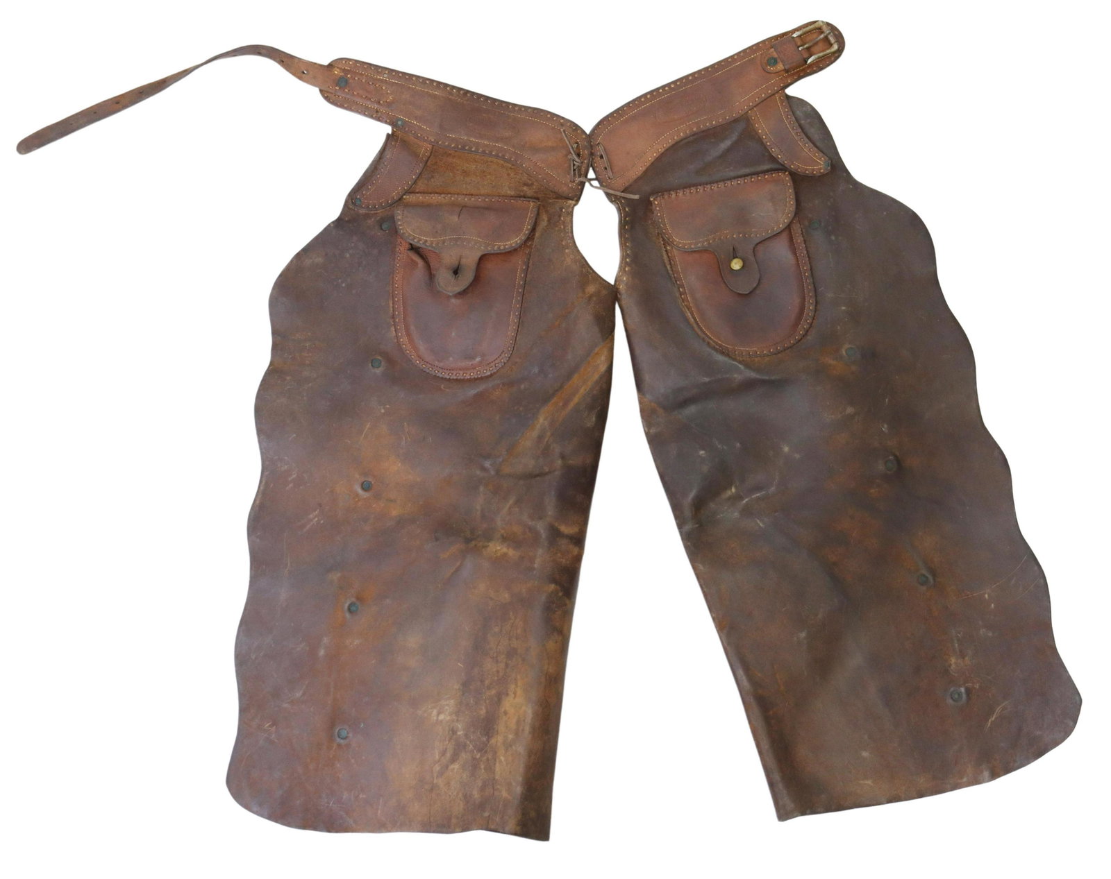 COWBOY CHAPS, HISTORIC VISALIA STOCK SADDLE CO.: (pair) Vintage cowboy brown leather chaps with makers mark of "Visalia Stock Saddle Company, San Francisco, Cal.", each leg with a pocket with one lacking button, three leather conchos at each leg, ap