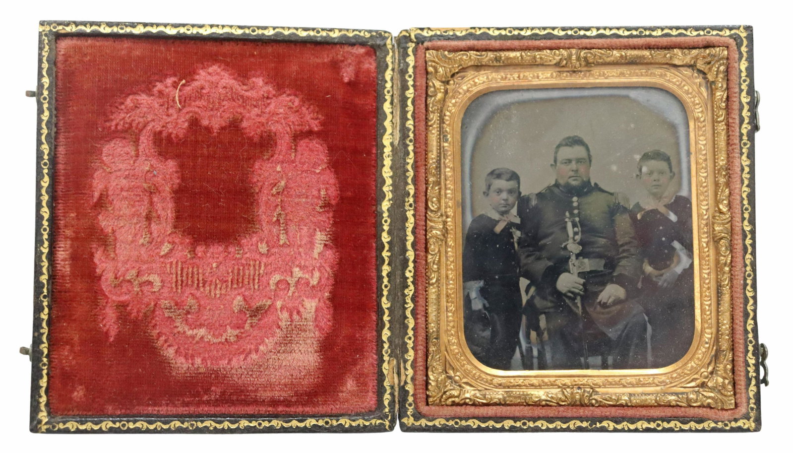 CIVIL WAR DAGUERREOTYPE SOLDIER & TWO BOYS: Civil War era daguerreotype picturing two young boys in matching uniform flanking a man, likely their father, dressed in northern militia uniform holding a militia sword likely 1840-1850 model with he
