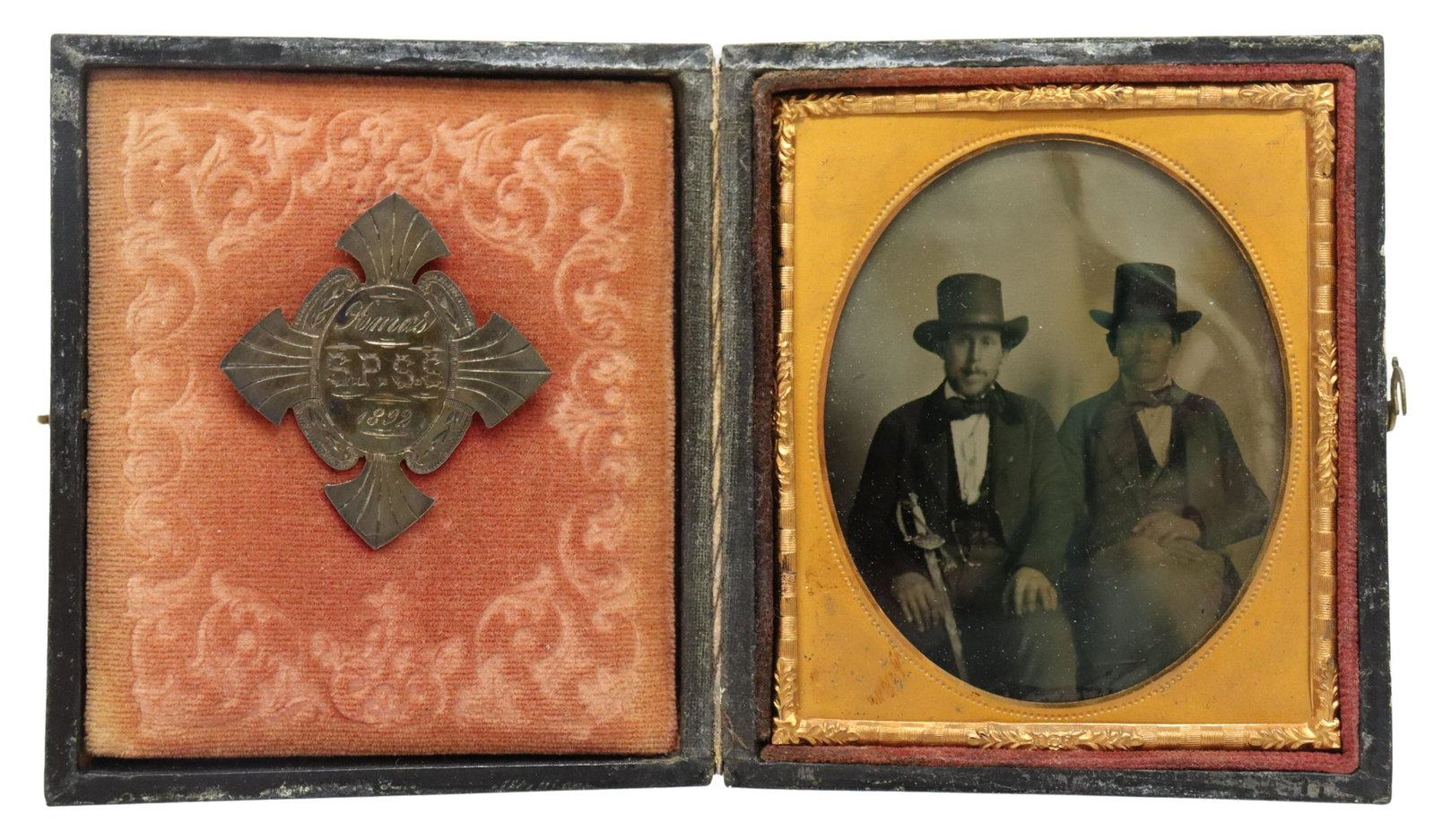 AMBROTYPE PHOTO, SERBIAN IMMIGRANTS ONE WITH SWORD: Ambrotype photo of two men, likely Serbian immigrants to the U.S., both wearing high hats, one with a sword, the photo case with a brass pin back dated 1892 and at center marked S.P.S.S. (Srpski Pravo