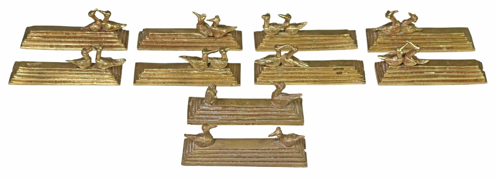 (10) CAST BRONZE BIRD MOTIF KNIFE RESTS: (lot of 10) Cast bronze knife rests, birds perched on stepped base, some wear and loss, approx 3.25"l, 1"w; 3lbs total Start Price: $100.00