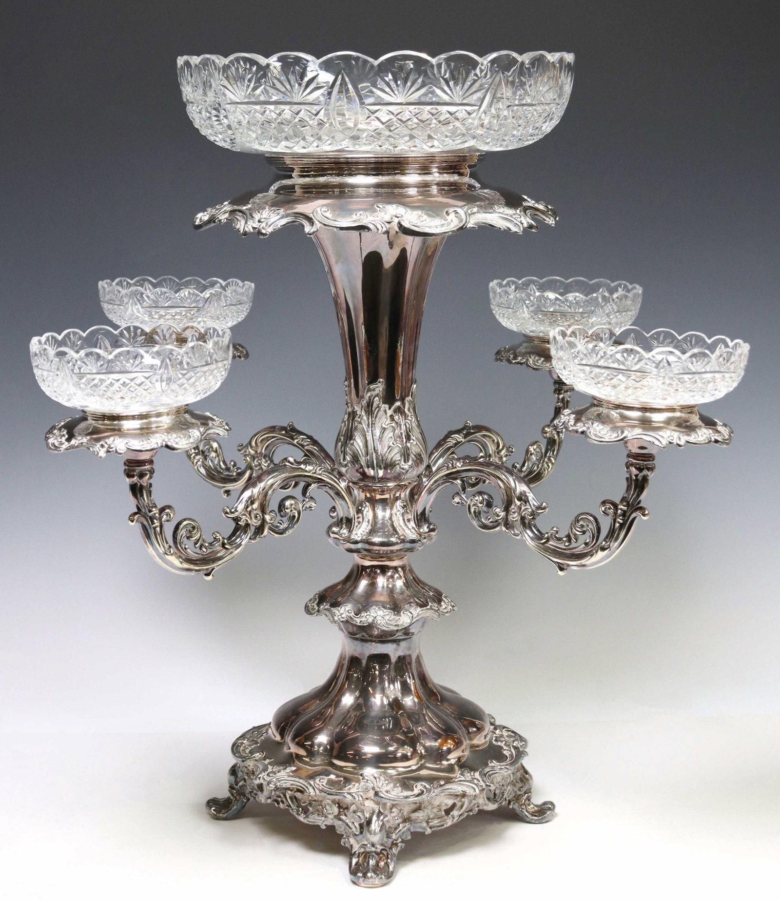 LARGE SILVERPLATE & CUT GLASS EPERGNE CENTERPIECE: Large silverplate epergne centerpiece, marked underfoot B.V (?), cut glass bowls with scalloped rim, fan and diamond pattern, supported by removable foliate scroll arms, acanthus-clad standard, rising