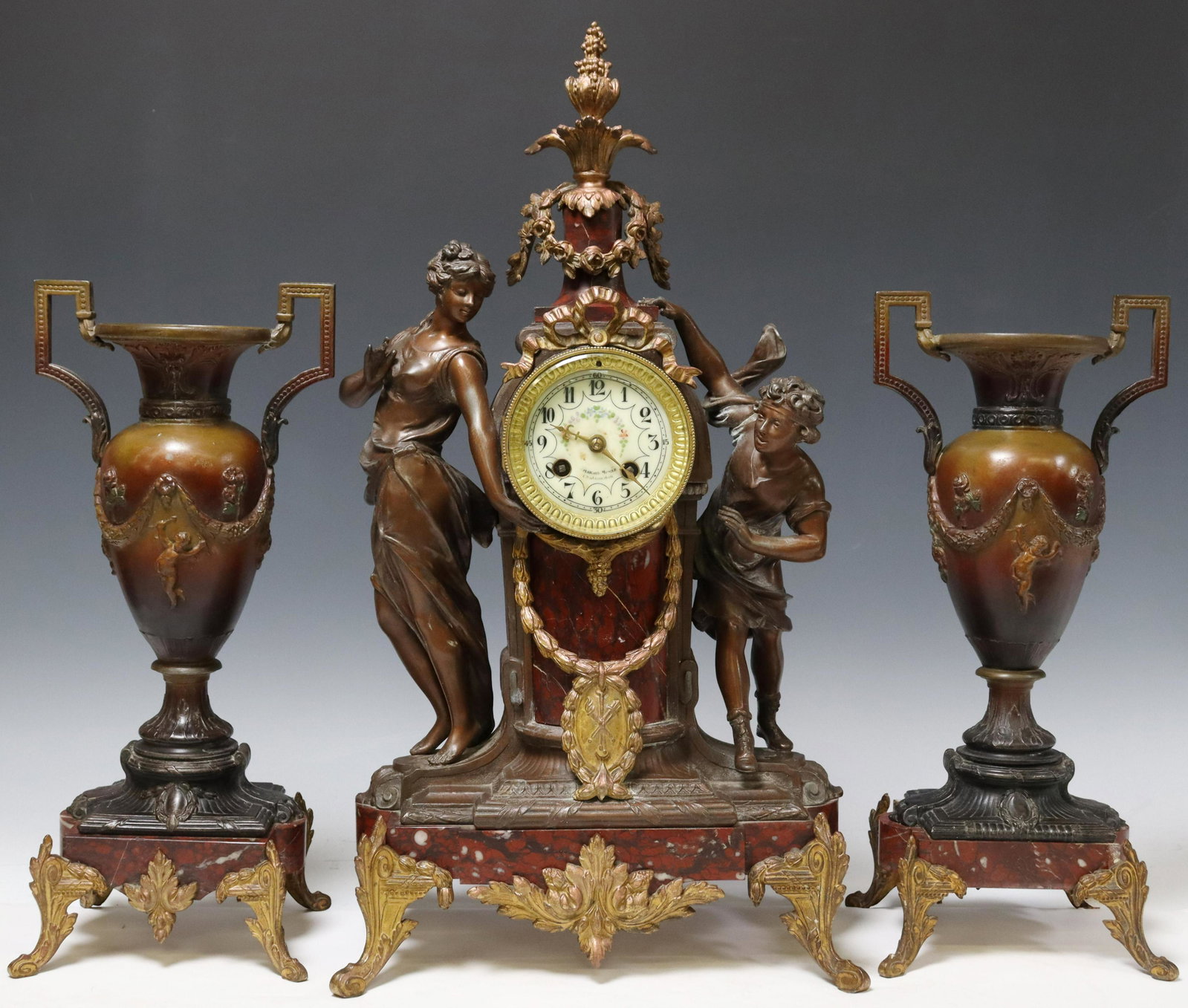 (3) FRENCH FIGURAL MANTEL CLOCK & GARNITURES: (lot of 3) French patinated metal and marble mantel set, early 20th c., including: (1) shelf clock, enamel fancy dial inscribed Marais-Moree Chateaudun, Arabic numeral hour markers, time-and-strike mo