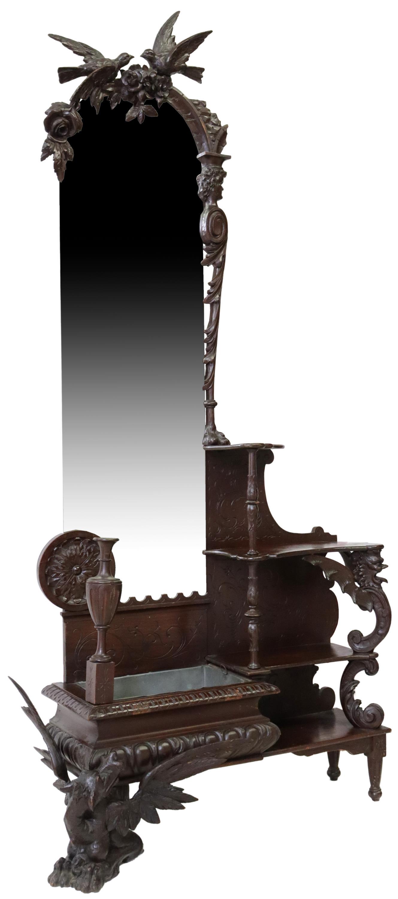 ITALIAN RENAISSANCE REVIVAL MIRRORED JARDINIERE: Italian Renaissance Revival carved mirrored hall jardiniere, 19th c., arched beveled mirror, with love birds crest, over lined jardiniere, flanked to the right by four open shelves, having mythical be
