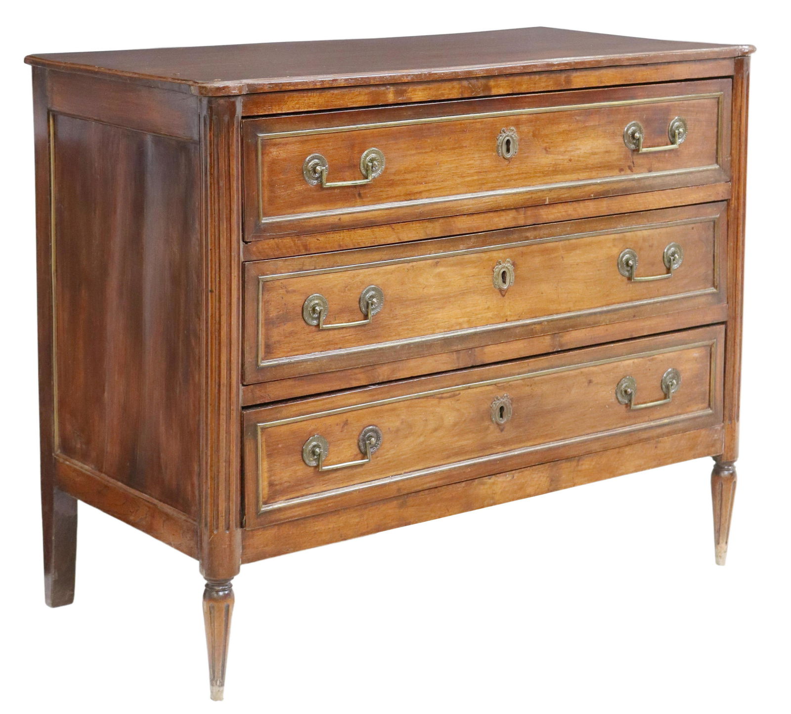 FRENCH LOUIS XVI STYLE MAHOGANY COMMODE: French Louis XVI style mahogany commode, 19th c., fitted with three drawers, faced with gilt-metal banding, flanked by fluted side supports, rising on tapered legs, filled separation at right side pan