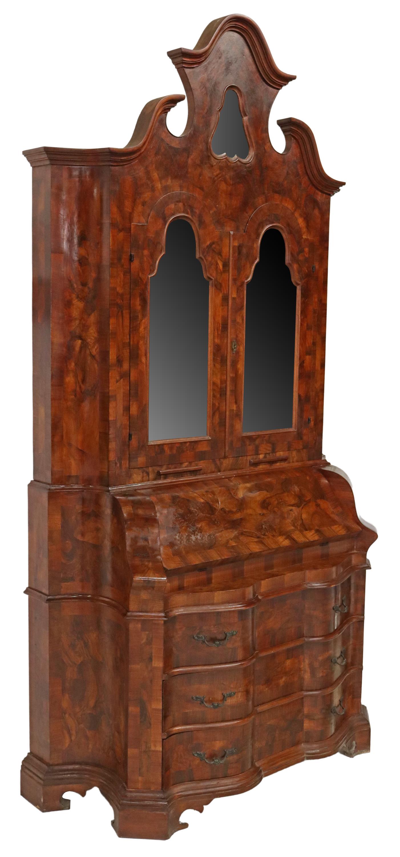 VENETIAN BURLWOOD MIRRORED SECRETARY BOOKCASE: Venetian walnut secretary bookcase, early 20th c., split pediment, two doors faced with flat mirror plates, opening to fabric-lined shelves, over the hinged slant-front writing surface, lower serpenti
