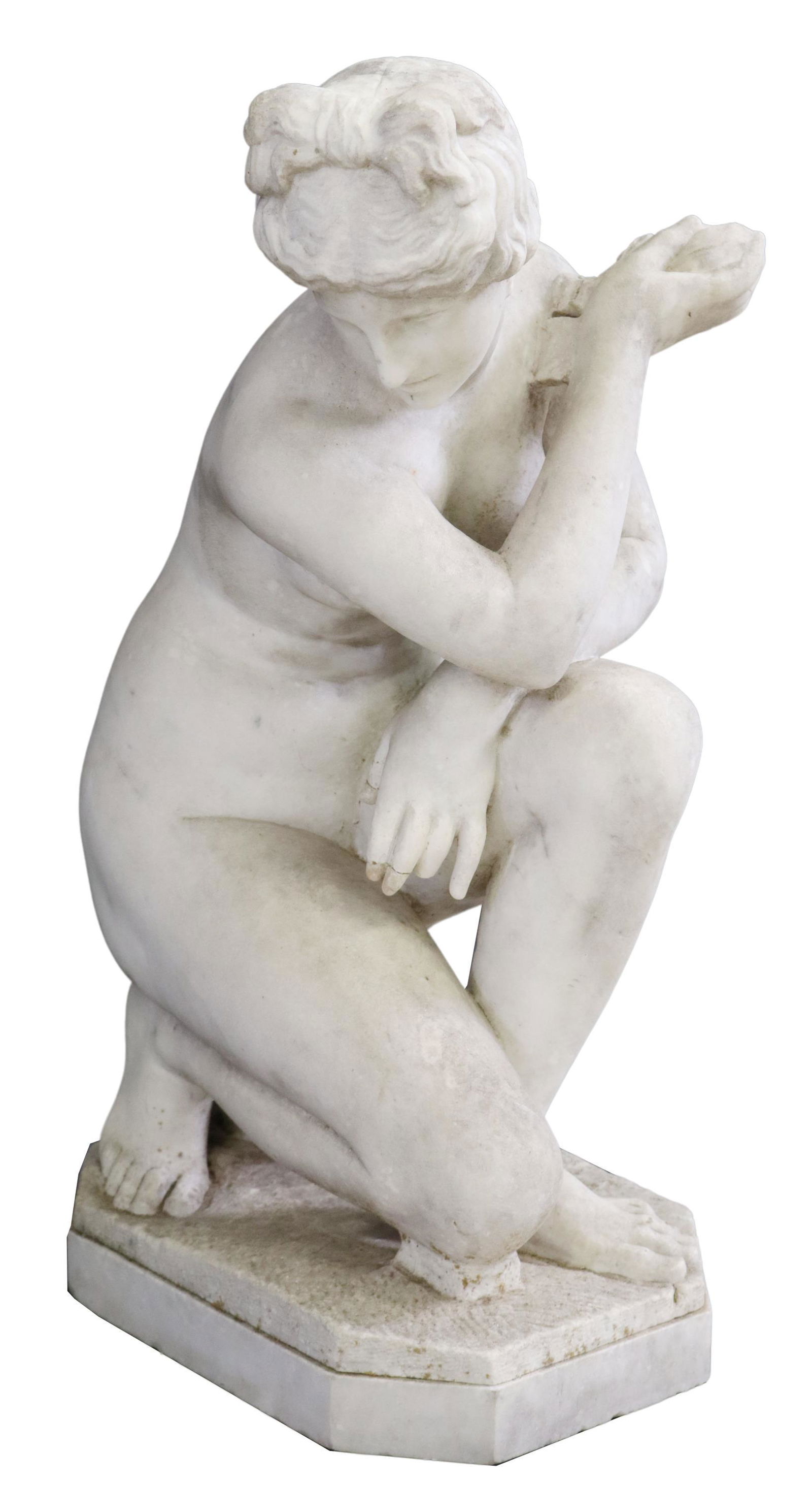 CROUCHING VENUS CARVED MARBLE SCULPTURE: Carved marble sculpture, Crouching Venus, on one knee, seated on urn, rising on octagonal base, restoration and loss to fingers, evidence of outdoor use, approx 28"h, 13.5"w, 15.5"d Start Price: $400.