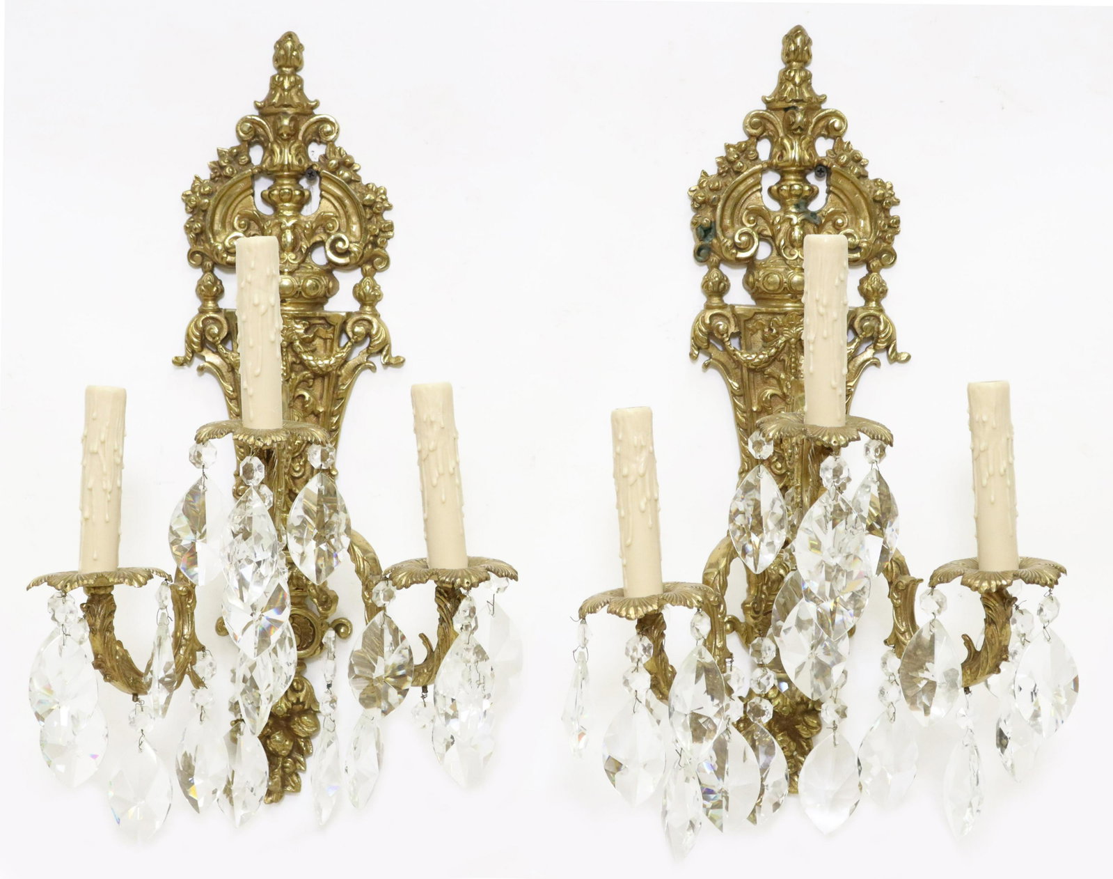 (2) BRONZE & CRYSTAL THREE-LIGHT SCONCES: (pair) Bronze and crystal three-light sconces, tapered backplate, foliate scroll arms, hung with crystal prisms, approx 21.75"h, 13"w, 10"d **Provenance: An important San Antonio, Texas estate** Start