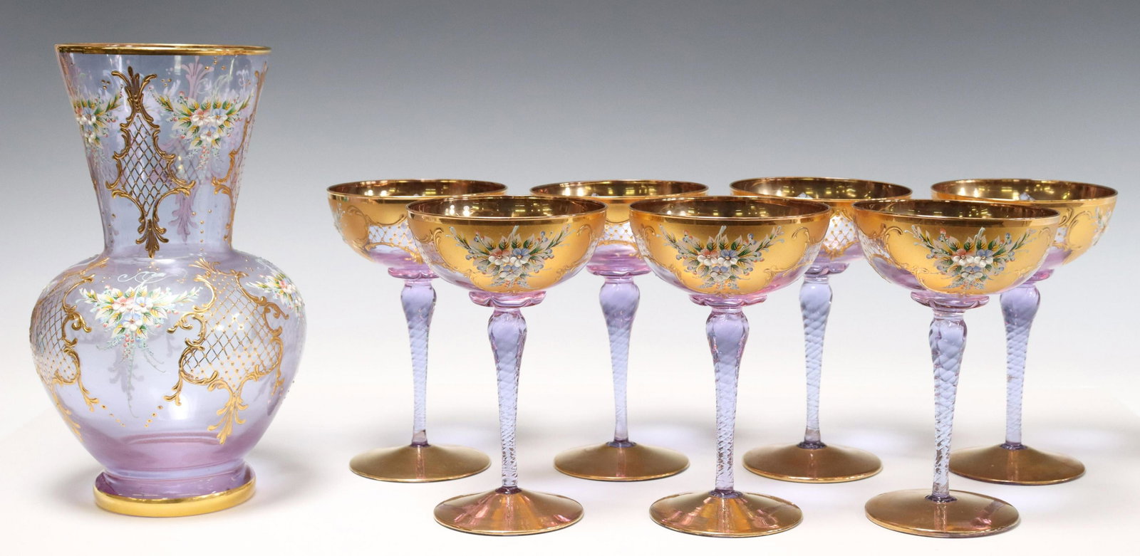 (8) ITALIAN PARCEL GILT & ENAMELED GLASSWARE: (lot of 8) Italian parcel gilt and enameled glassware, all having gilt rim, over enameled floral bouquets and gilt latticework, on opaque periwinkle ground, including: (1) baluster-form vase, approx 1