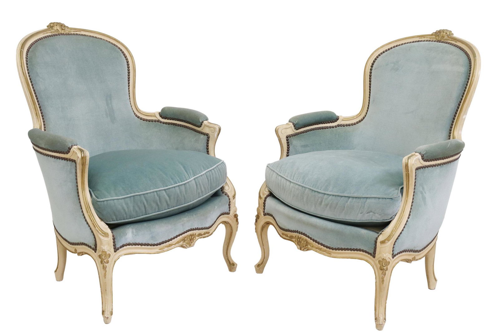 (2) FRENCH LOUIS XV STYLE UPHOLSTERED BERGERES: (pair) French Louis XV style painted bergeres, 20th c., having floral crest, in a blue upholstery, with nailhead trim, rising on cabriole legs, ending in whorl feet, approx 38.25"h, 26"w, 29"d, seat h