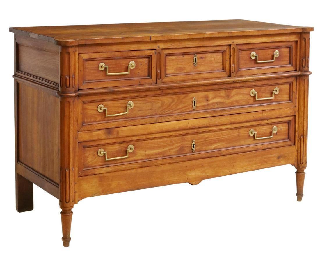 FRENCH LOUIS XVI STYLE FRUITWOOD COMMODE: French Louis XVI style fruitwood commode, 19th c., projecting fluted corner posts, three small drawers, over two long drawers, rising on tapered front legs, approx 33.75"h, 53"w, 23.5"d Start Price: $