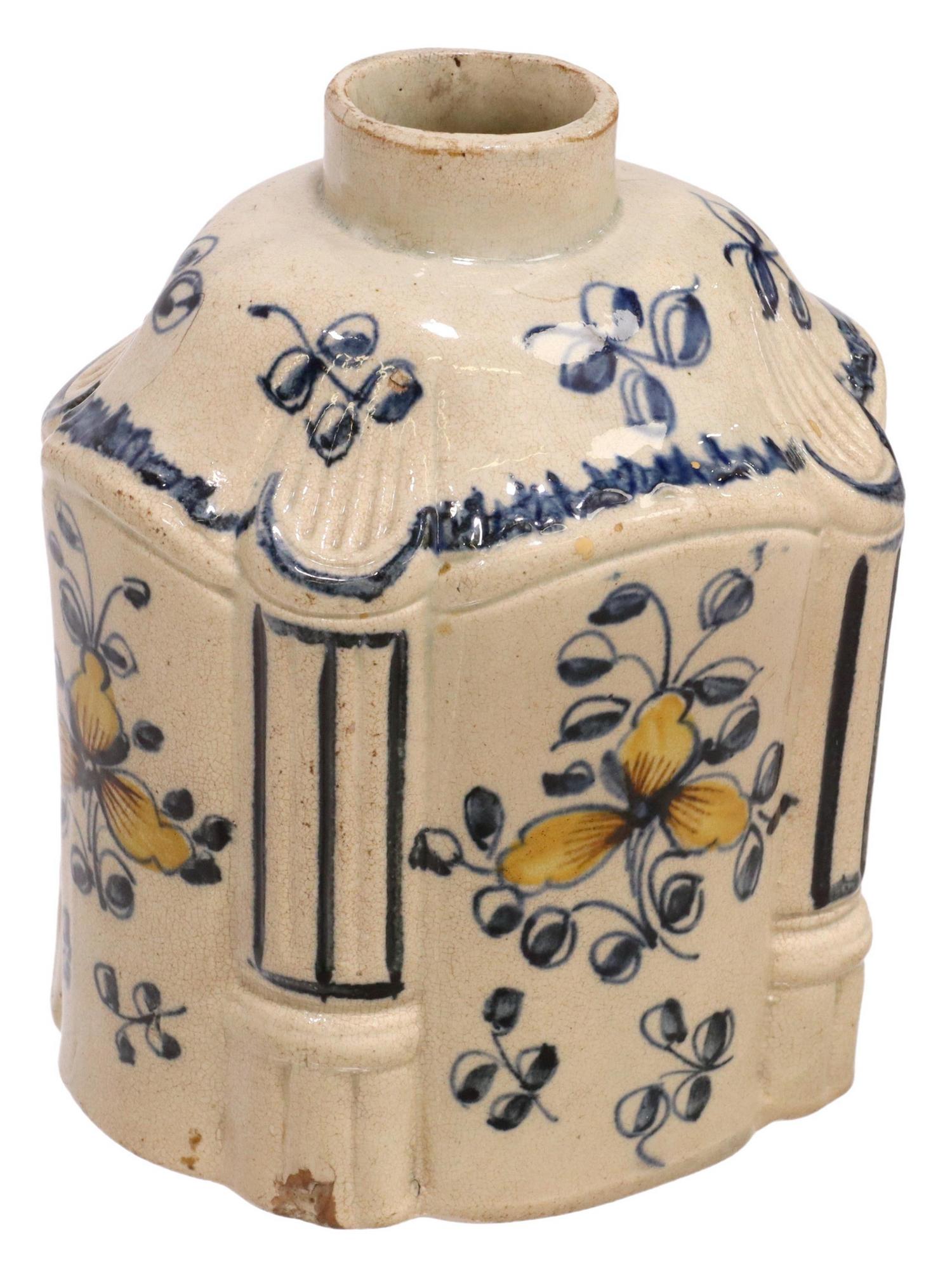 ENGLISH PEARLWARE TEA CADDY, 18TH C.: English creamware tea caddy/ canister, late 18th c., blue and yellow glazed flowers, lacking lid, small chips around edge of foot, approx 4.5"h, 4"w, 3.5"d, 0.5lbs Start Price: $50.00