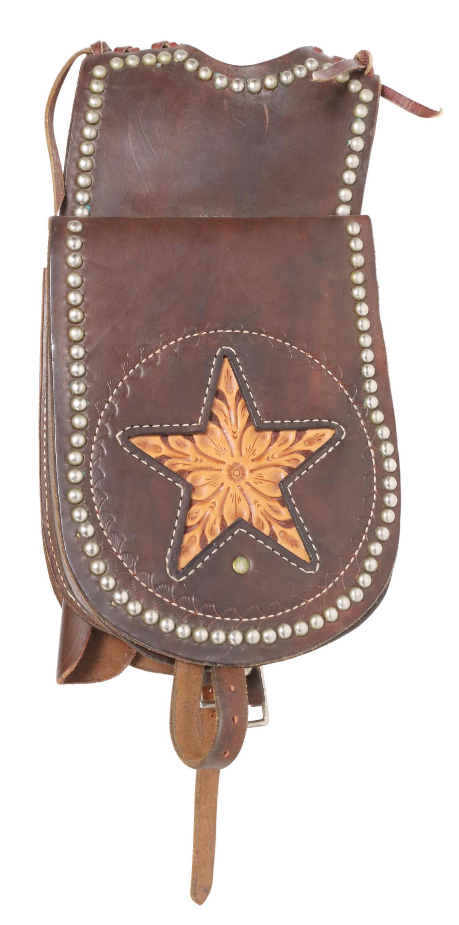 TOOLED LEATHER POMMEL SADDLE BAGS WITH HOLSTER: Western tooled leather pommel saddlebags, Lyle E. Henderson, Kearney, Nebraska, stitched and tooled brown leather, with floral tooled leather stars to each bag flap, nailhead trim, one bag with pistol