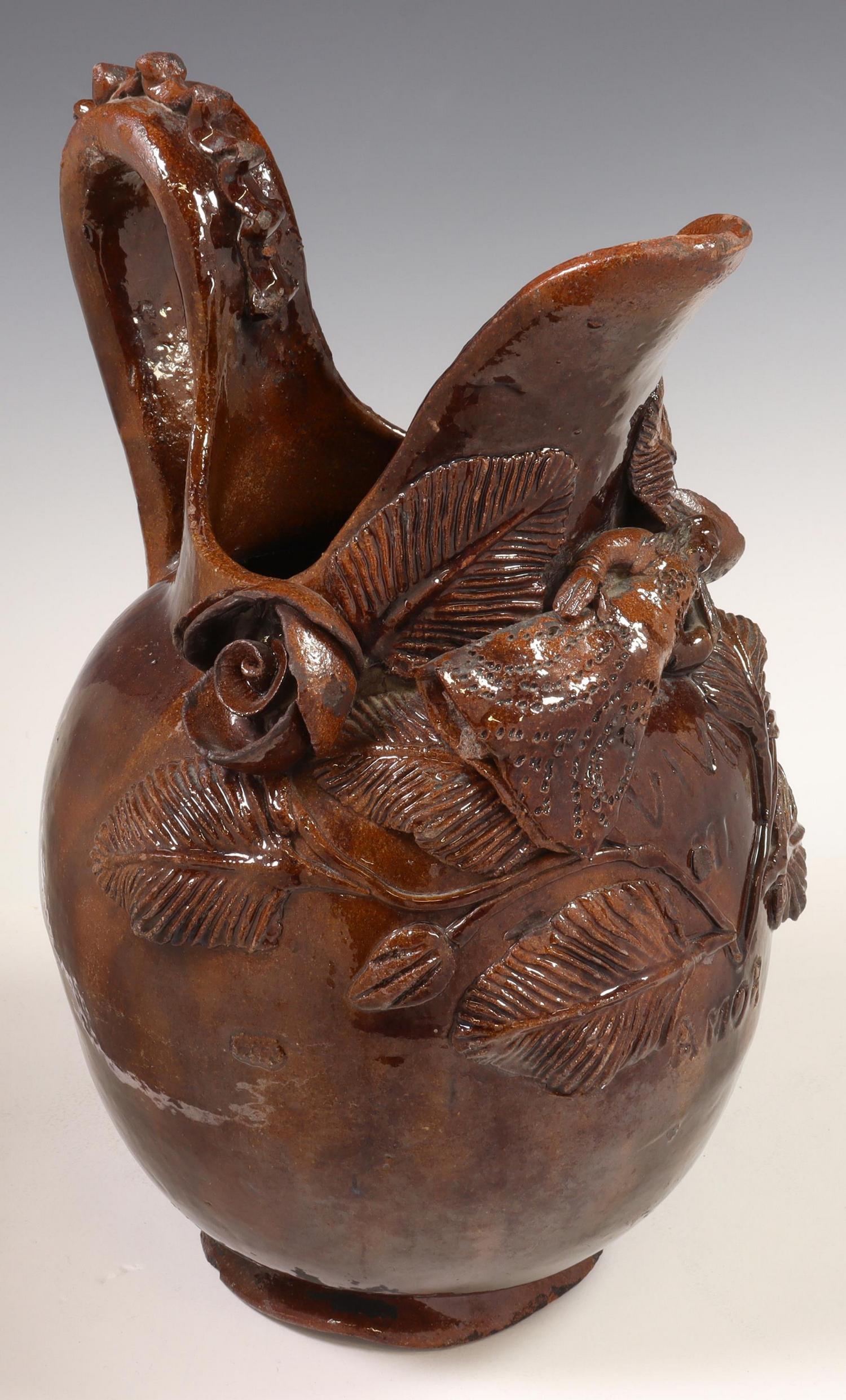 PUEBLA FOLK ART POTTERY FIGURAL PULQUE PITCHER: Glazed earthenware folk art Pulque pitcher, Puebla, Mexico, late 19th/ early 20th c., with applied roses and central reclining female figure, inscribed "Viva Mi Amor" (Long Live my Love) at front face