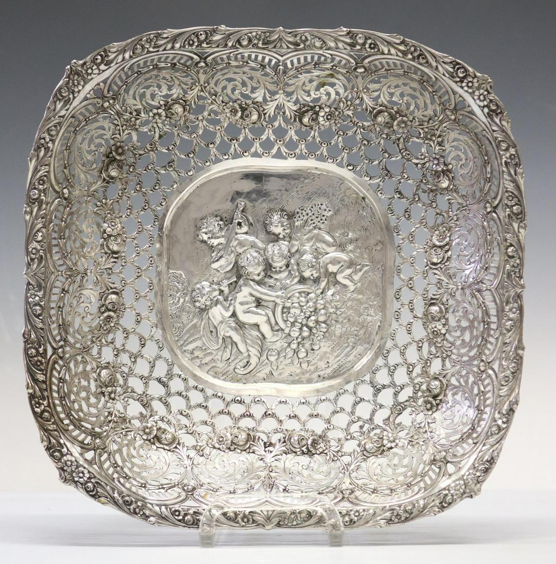 GERMAN ROCOCO REVIVAL 800 SILVER PIERCED BASKET: German 800 silver basket, in the Rococo taste, reticulated frame with roses, foliate scrolls, central reserve with putti in relief, approx 2.5"h, 12.5"w, 12.5"d, 15.27ozt **Provenance: A fine Austin, 