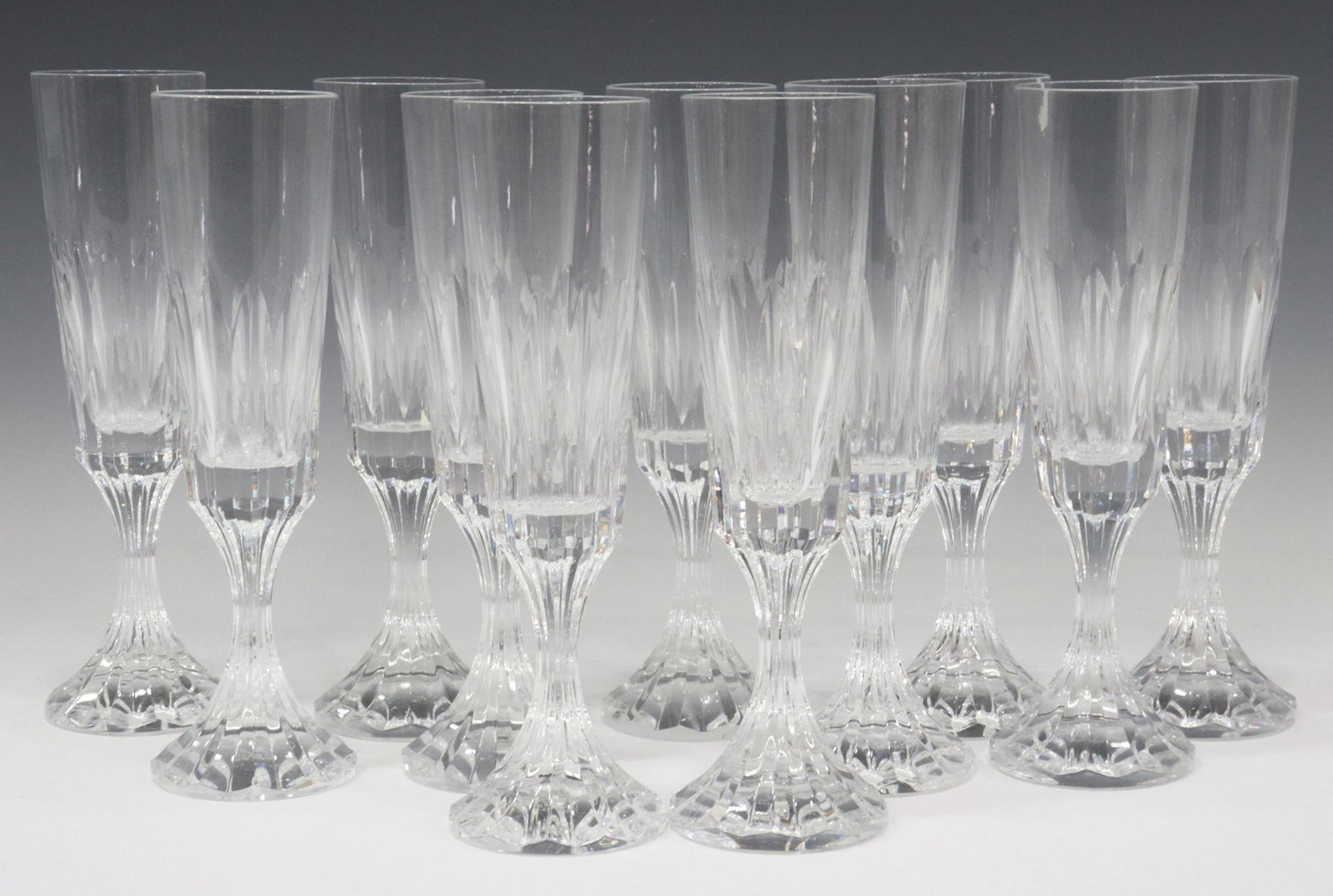 (11) FRENCH BACCARAT 'D'ASSAS' CHAMPAGNE FLUTES: (lot of 11) French Baccarat "D'Assas" cut crystal fluted champagne glasses, each with vertical cuts to bowl and stem, all bearing acid-etched mark underfoot, approx 8.5"h, 2.25"diam; 8.5lbs total Star