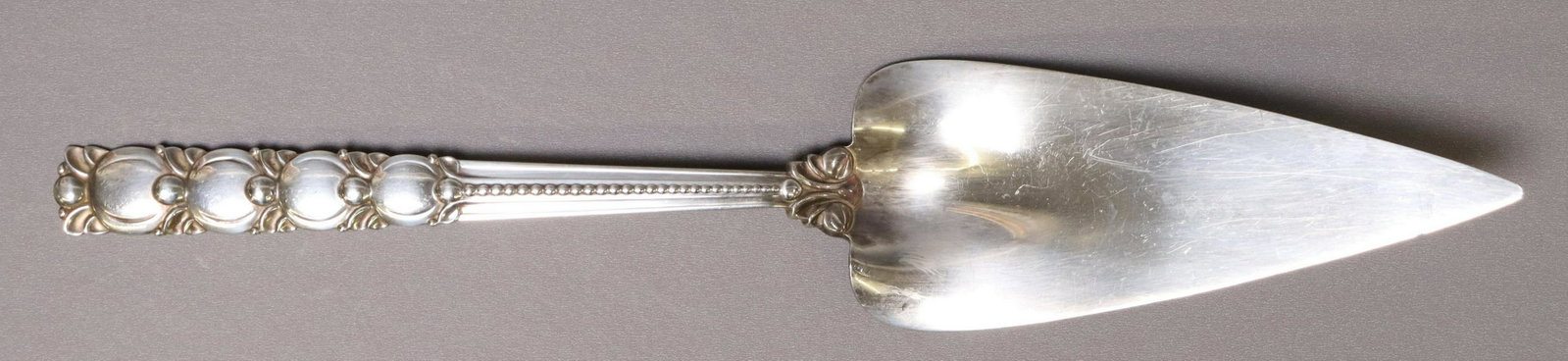 TIFFANY & CO. TOMATO/ EXPOSITION STERLING SERVER: American sterling silver pie server, Tiffany & Company, in the "Tomato" or "Exposition" pattern, c.1930s, directorship of John C. Moore II, approx 12 1/8"l, 5.33ozt Start Price: $80.00