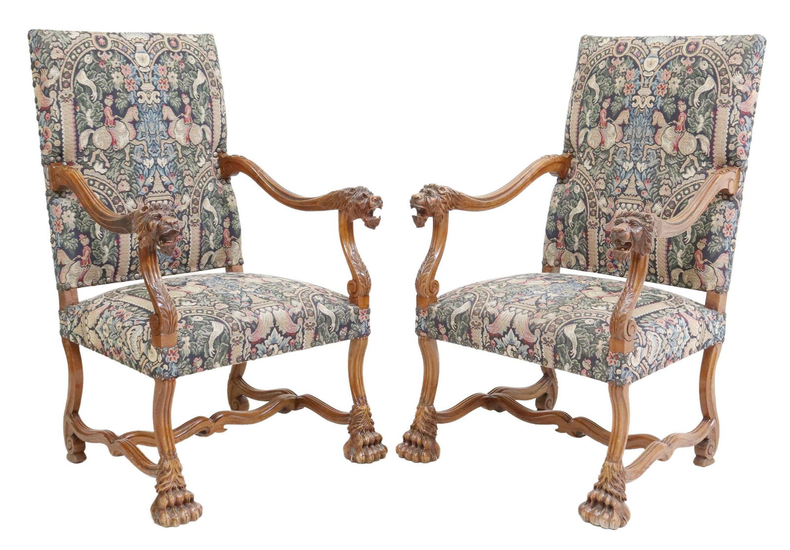 (2) FRENCH RENAISSANCE REVIVAL HIGHBACK ARMCHAIRS: (pair) French Renaissance Revival carved highback armchairs, 20th c., in a tapestry style upholstery, with decorative nailhead trim, lion head handholds, rising on stretcher-joined legs, ending in paw