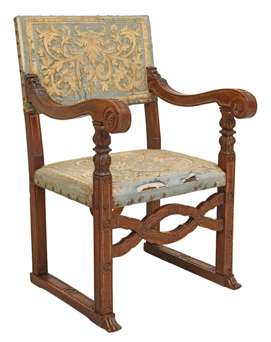 ITALIAN BAROQUE CARVED WALNUT ARMCHAIR: Italian Baroque carved walnut armchair, 18th c., back and seat in worn patterned upholstery, with decorative nailhead trim, scrolled handholds, over carved and pierced apron, rising on stretcher-joine