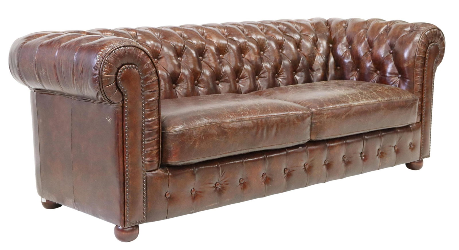 CHESTERFIELD STYLE BROWN TUFTED LEATHER SOFA: Chesterfield style two-seat sofa, 20th c., in brown button-tufted leather upholstery, with nailhead trim, rising on bun feet, approx 29"h, 85"w, 34"d, seat height: approx 18"h Start Price: $600.00