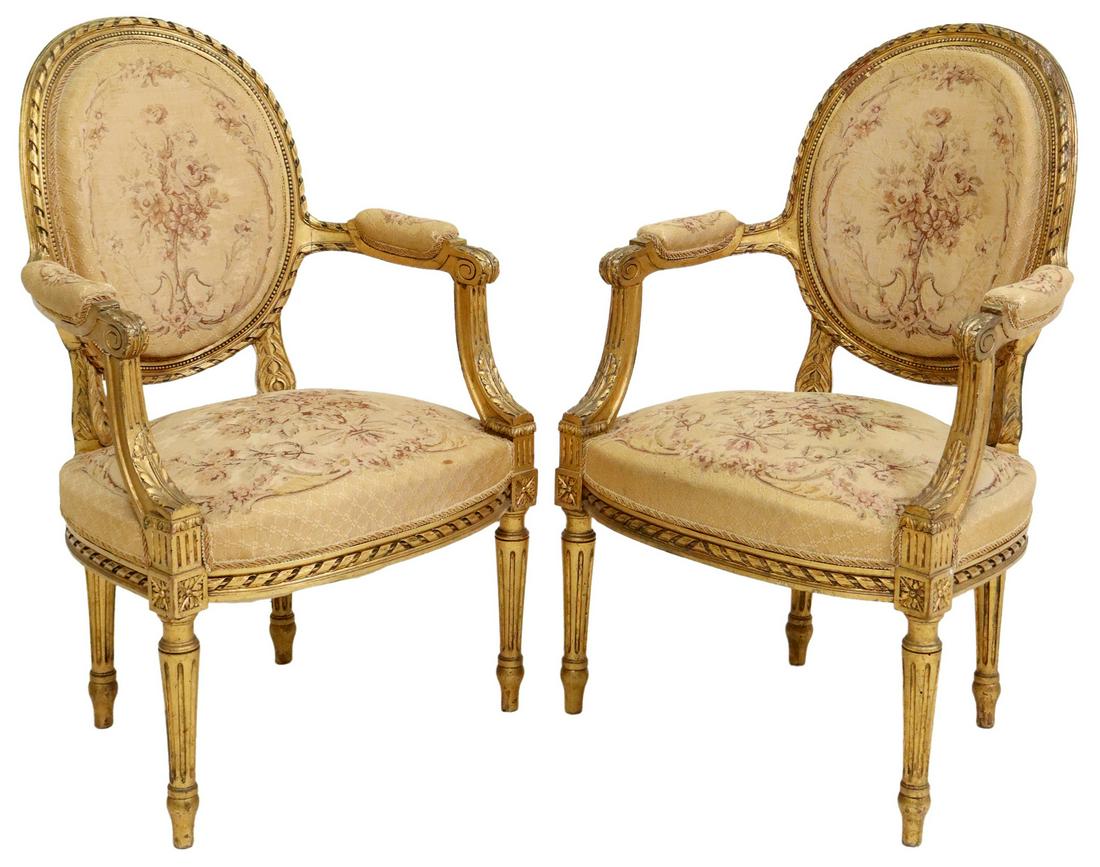 (2) FRENCH LOUIS XVI STYLE GILTWOOD FAUTEUILS: (pair) French Louis XVI style giltwood oval back armchairs, late 19th c., having floral tapestry, padded arms, rising on tapered ribbed legs, approx 37"h, 23.75"w, 19.5"d, seat height: 18.5"h **Note: 