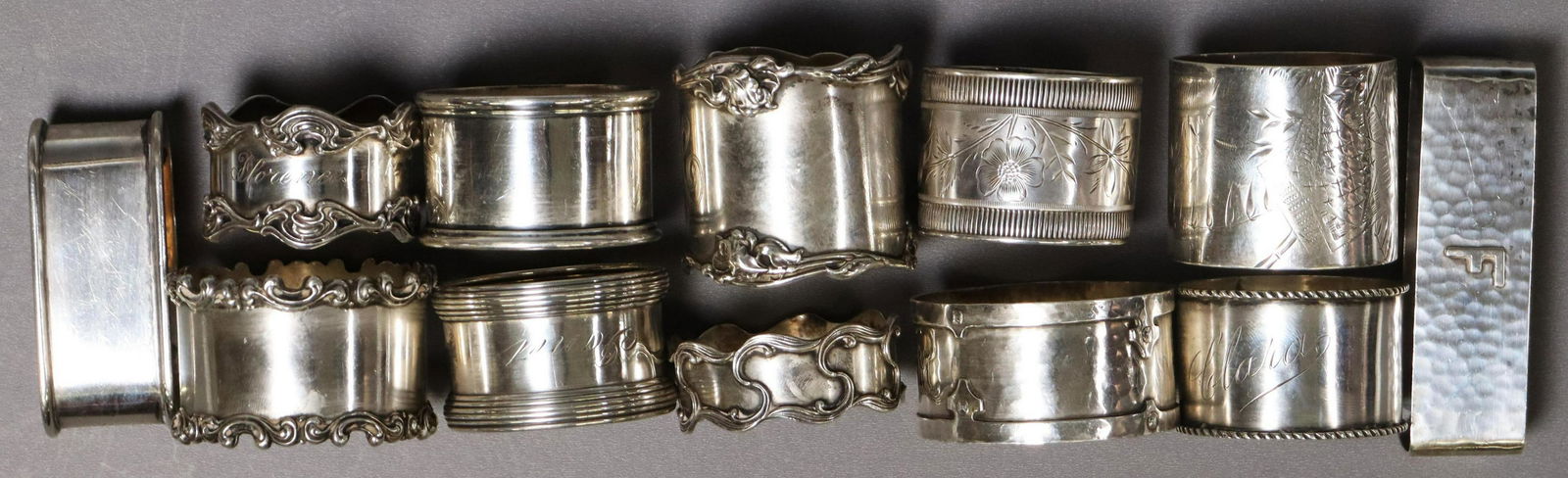 (12) GROUP OF STERLING SILVER NAPKIN RING HOLDERS: (lot of 12) Sterling silver napkin ring holders, most monogrammed or personalized, various styles with foliate, engraved and other aesthetic motifs, highlighted makers include: Gorham, R. Blackinton,