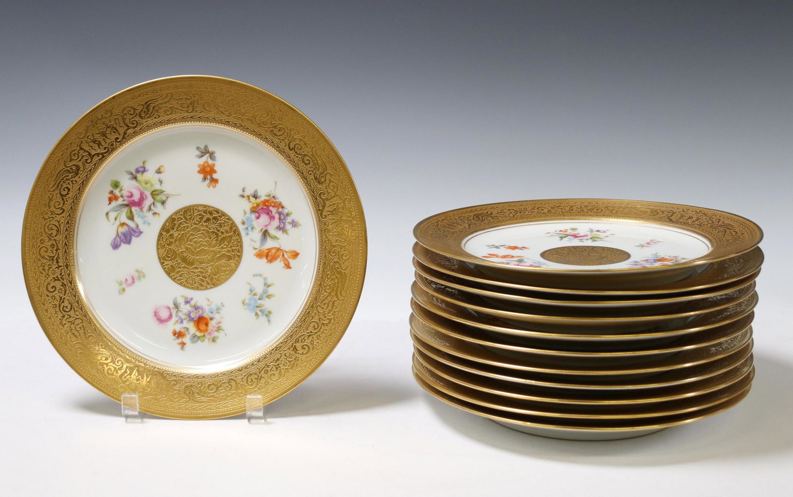 (12) CZECH GILT ENCRUSTED PORCELAIN CHARGERS: (lot of 12) Porcelain chargers, Springer & Company, EPAIG, Czechoslovakia, gilt encrusted border with putti, transferred floral pattern, (one) intact with hairline at rim, approx 10 7/8"diam; 16.25lbs