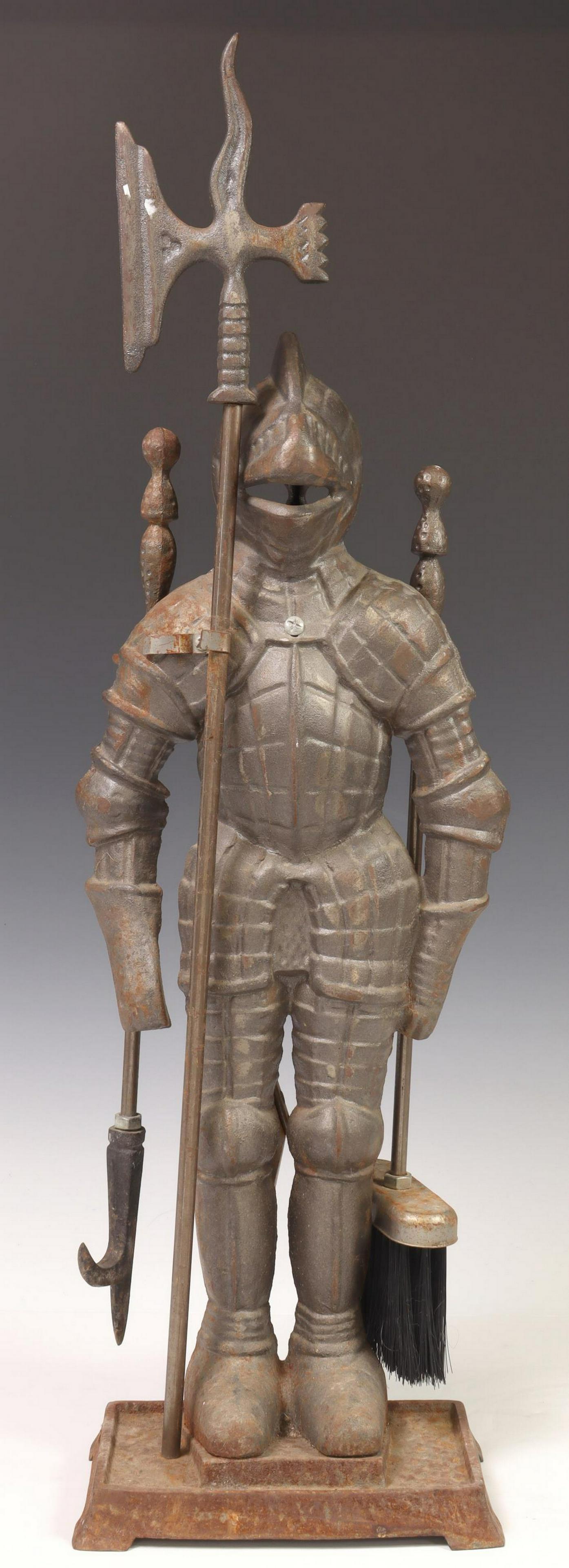 ENGLISH CAST IRON FIREPLACE KNIGHT WITH TOOLS: English cast iron fireplace knight, 20th c., holding halberd axe-form poker, fireplace tools to back, on plinth base, approx 28.25"h, 9.25"w, 7.5"d, 15.75lbs total Start Price: $100.00
