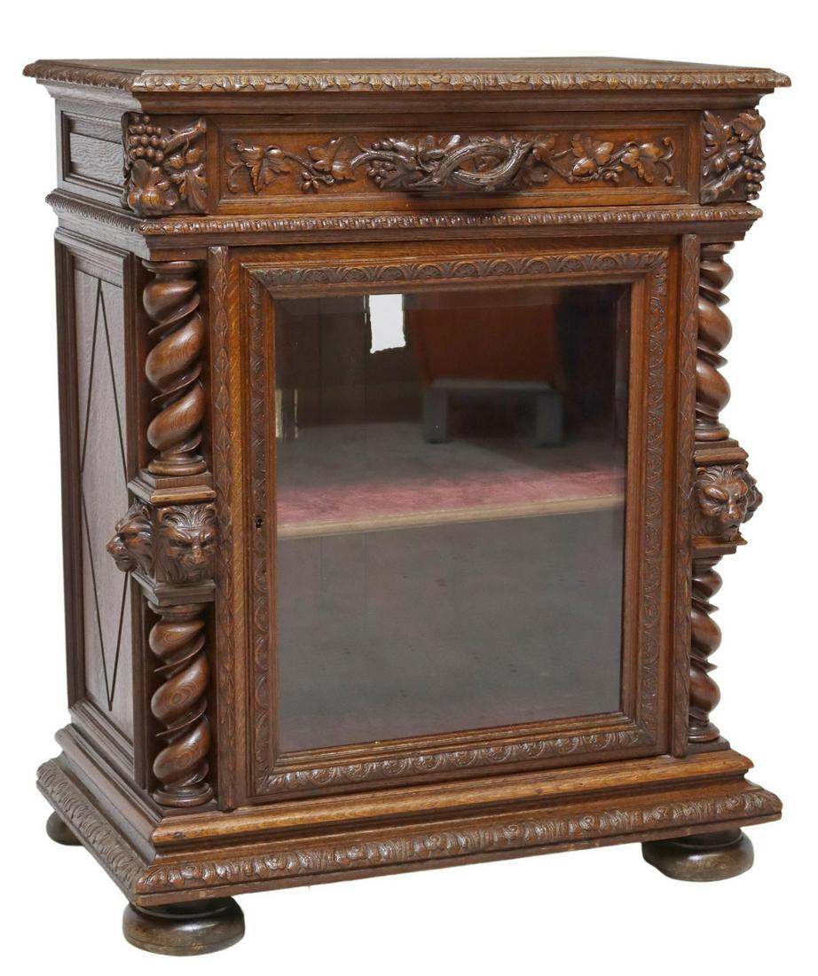FRENCH HENRI II STYLE CARVED OAK SIDE CABINET: French Henri II style oak cabinet, 19th c., drawer with branch-form handle, lined interior, cabinet door with beveled glass inset, twist pilasters with carved lion's masks, rising on bun feet, filled 