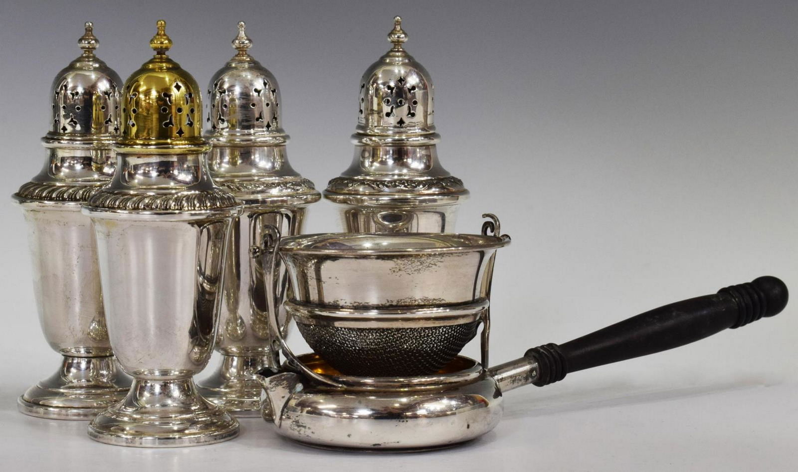 5) GORHAM STERLING SHAKERS & STERLING TEA STRAINER: (lot of 5) Sterling silver group, including: (2) Gorham shakers, numbered 759, having gadrooned rim, approx 4.5"h; (2) Gorham shakers, numbered 978, floral trim, approx 4.5"h, 4.88ozt; (1) Simons Brot