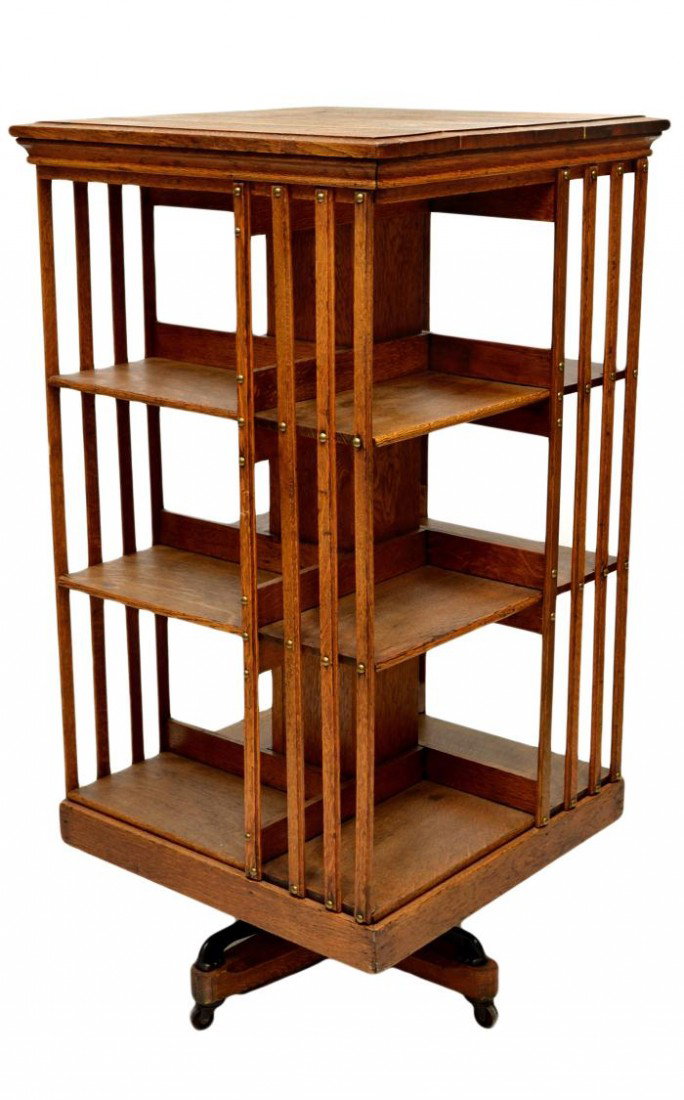 AMERICAN OAK THREE TIER REVOLVING BOOKCASE: American oak revolving bookcase, c.1900, refinished with remnants of John Danner Company maker information, three tiers with slat sides, twelve open shelves, all set on cast iron and wood quadripartit