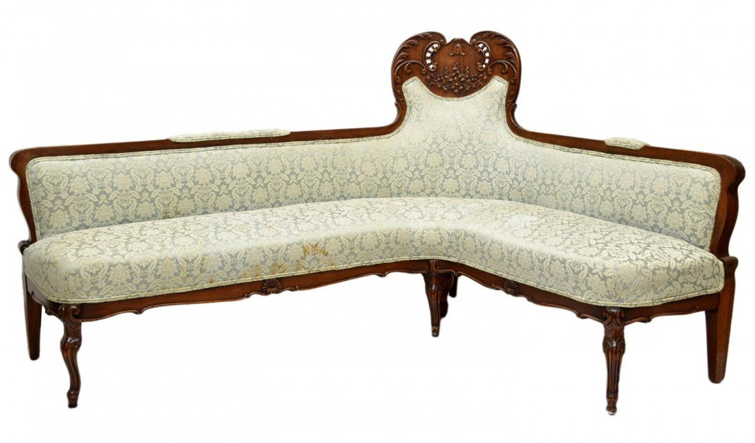 UNUSUAL ANTIQUE AMERICAN MAHOGANY CORNER SOFA: Antique mahogany framed corner sofa, American c. 1880, a laminated high back at the corner with applied foliate carving, one side extending 46" (outside), the other end extending 66" (outside), later 