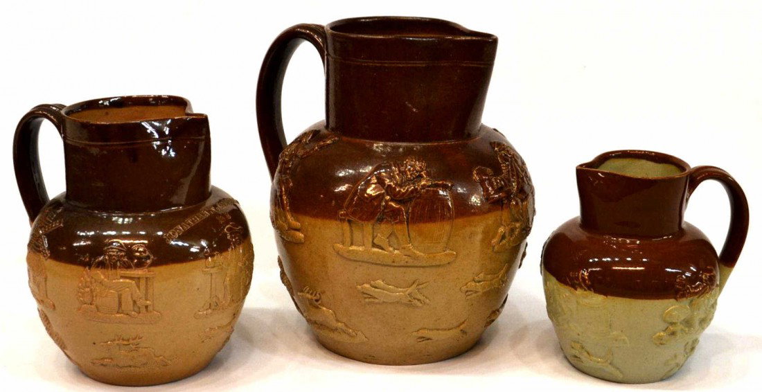 COLLECTION STONEWARE MOULDED RELIEF JUGS PITCHERS: ( lot of 3) Collection of stoneware molded relief pitchers, depicting harvest and tavern scenes, one impressed "Jonathan T. Campbell 1892," various makers, minor loss overall, largest: 8.25"h, 7.5"dia
