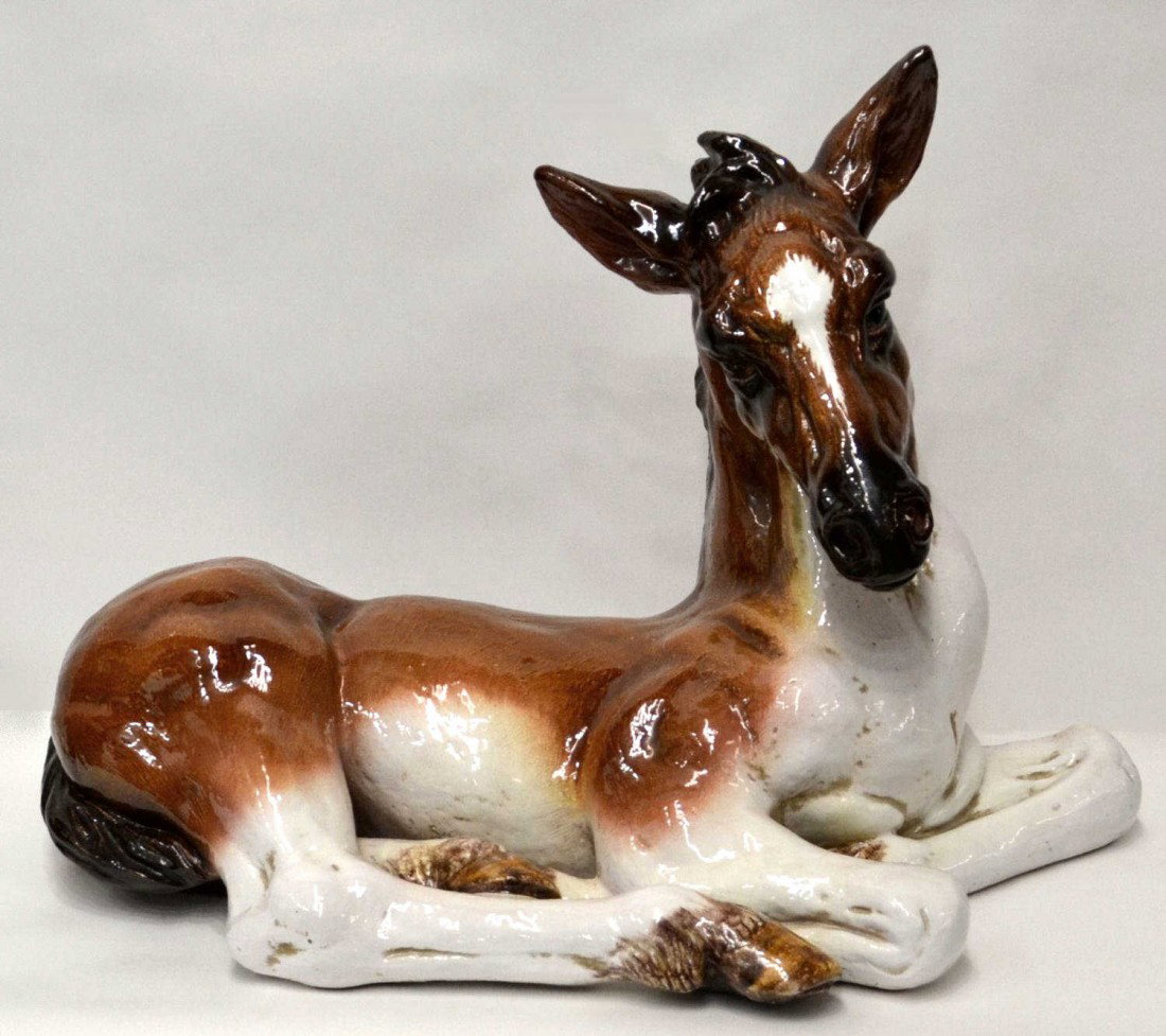 ITALIAN TERRACOTTA HORSE, A RESTING FOAL 22" x 30": Italian figure of a recumbent horse, 20th c., likely terracotta in a brown and white glaze, 22"h, 30"w, 15.5"d Start Price: $50.00