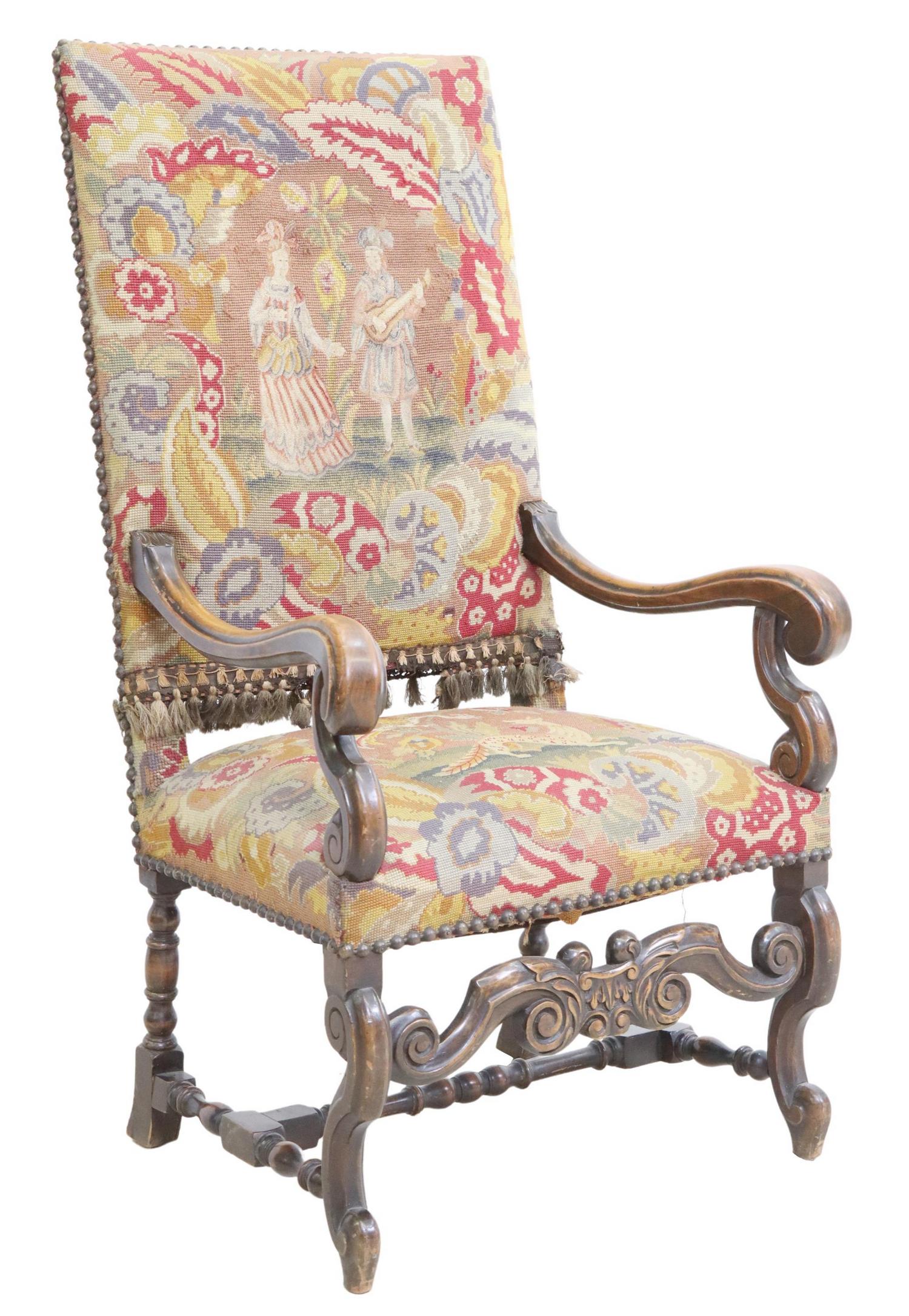 BAROQUE STYLE NEEDLEPOINT HIGHBACK ARMCHAIR: Baroque style highback armchair, 19th c., having needlepoint upholstery, with nailhead trim, scrolled handholds, over carved apron, rising on stretcher-joined legs, ending in whorl feet, approx 51.25"