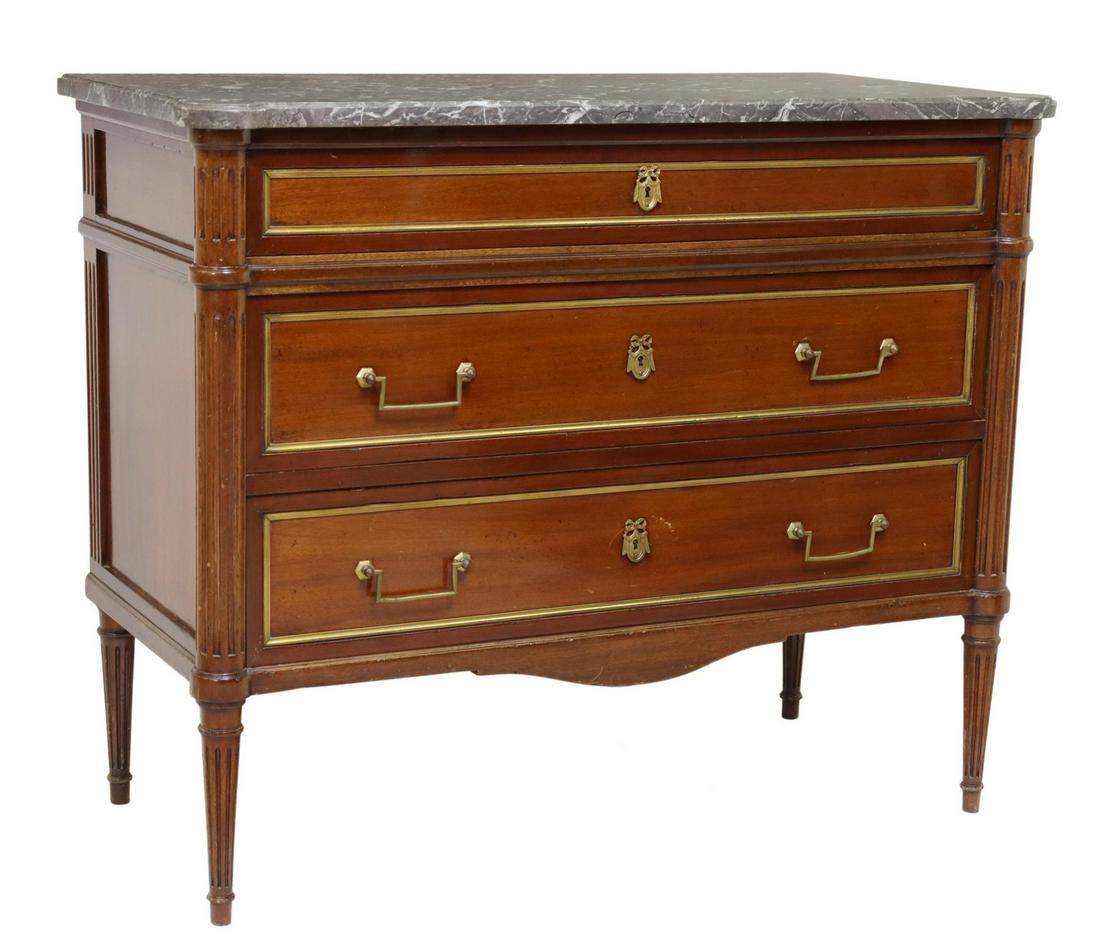 FRENCH LOUIS XVI STYLE MARBLE-TOP MAHOGANY COMMODE: French Louis XVI style marble-top mahogany commode, 20th c., three drawers with gilt metal trim, fluted corner posts, rising on tapered legs, marked at back of case, approx 35.25"h, 43.25"w, 20.5"d St